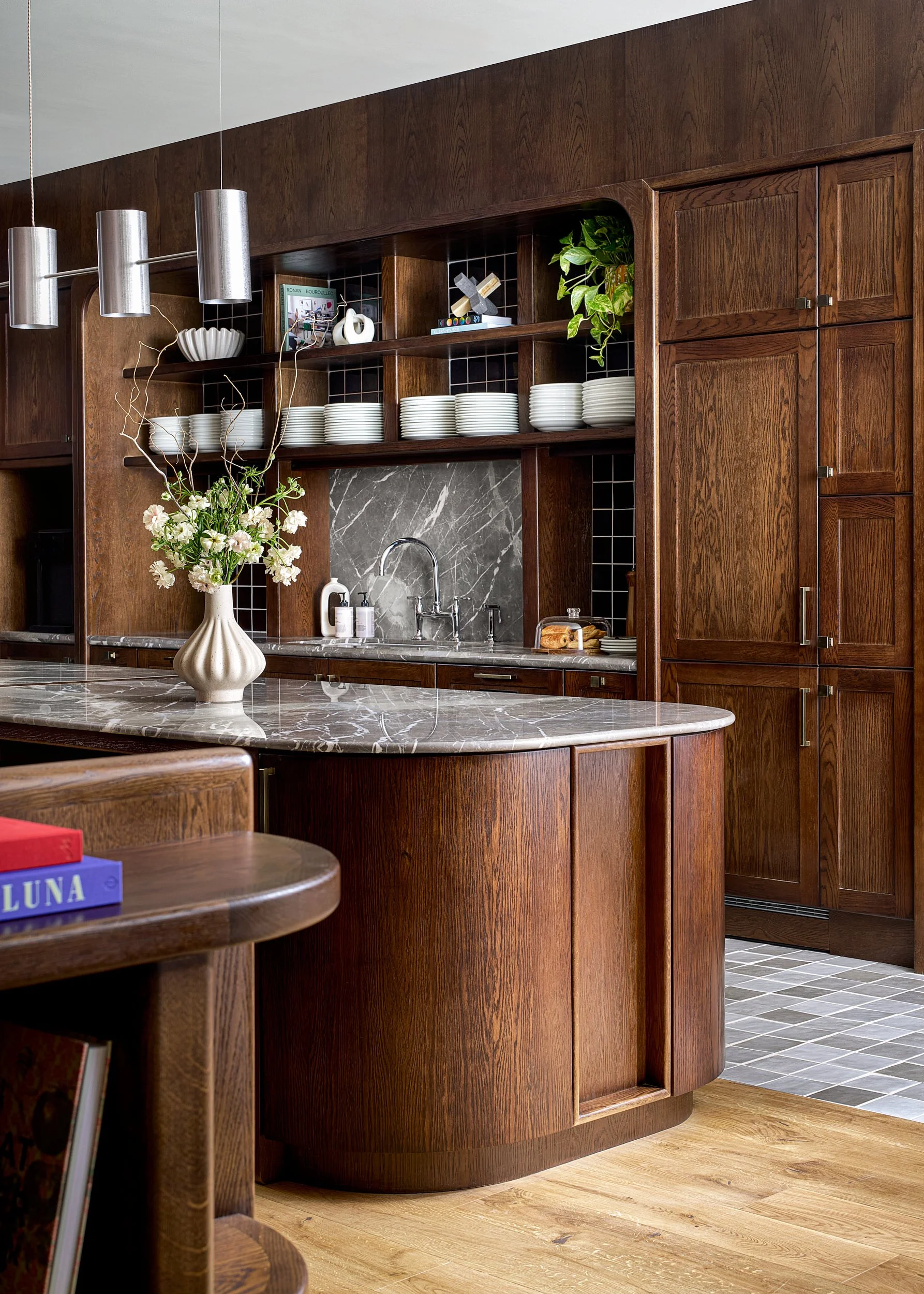 Shared kitchen and pantry at The Malin coworking space in Washington, D.C., with dark wood cabinetry and a marble backsplash.