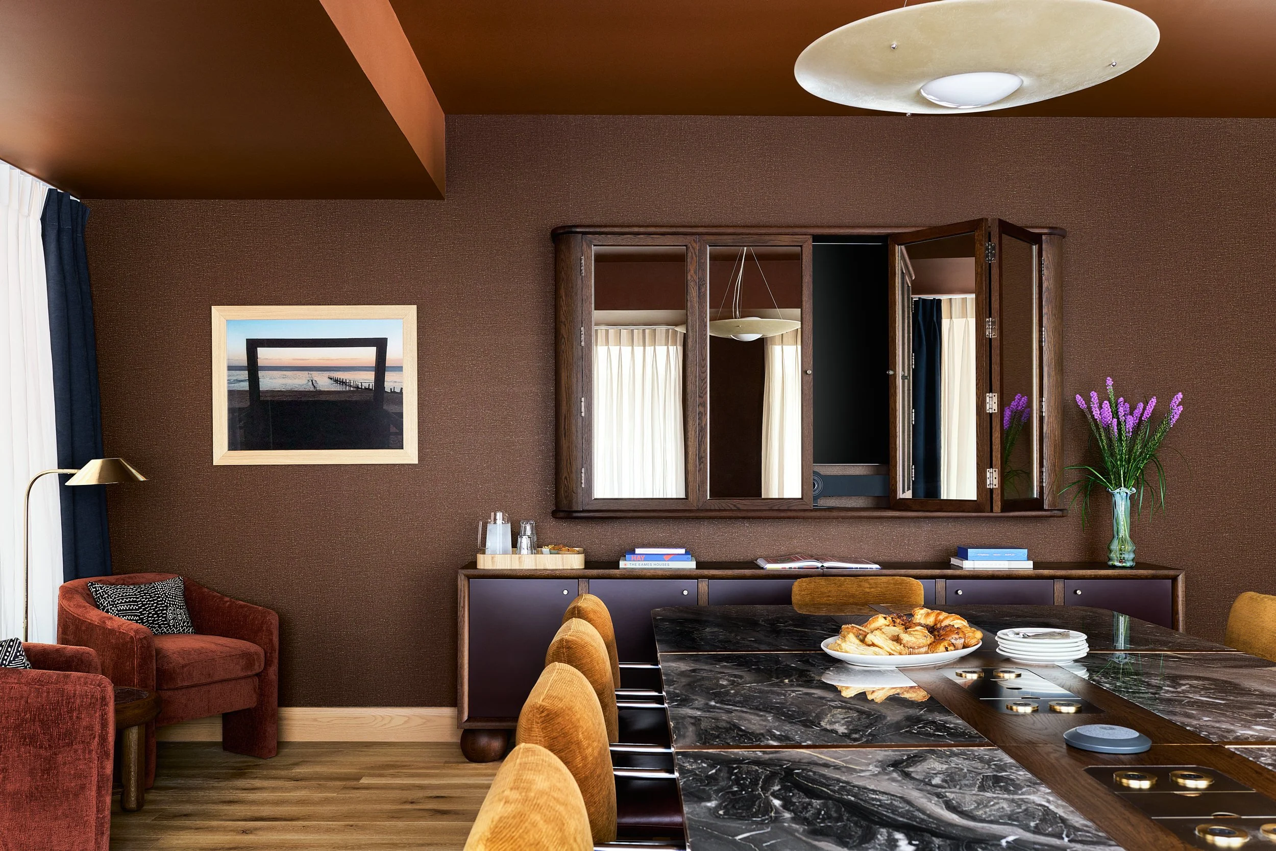 Meeting area at The Malin DC with a marble table and a mirrored wall cabinet open, revealing hidden storage.