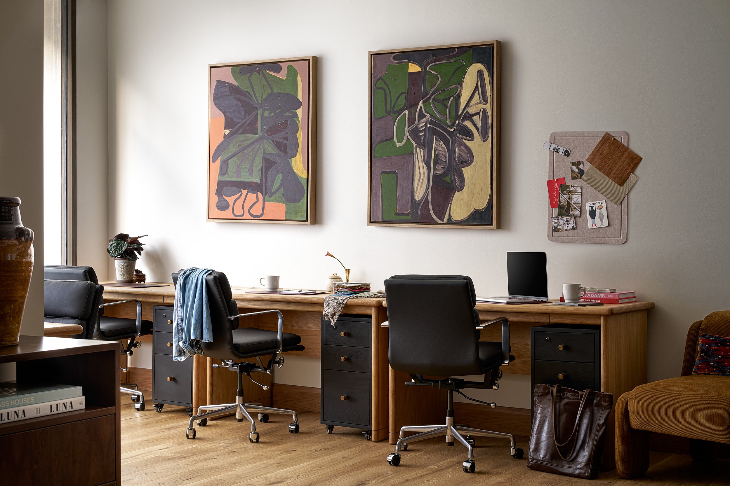 Shared private office at The Malin DC with wood desks, black leather chairs, and botanical abstract artwork.