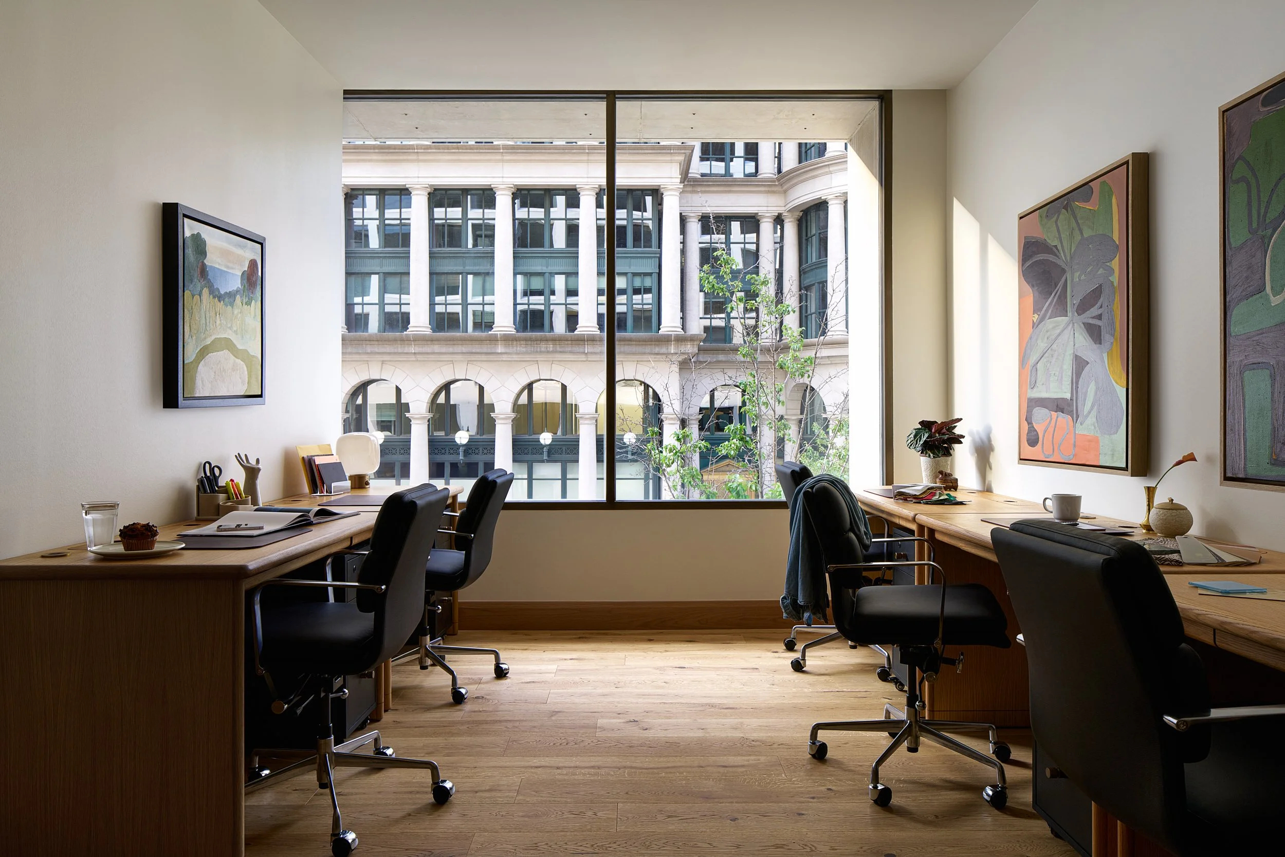 Private office at The Malin DC with facing wood desks and a window view of Washington DC's classical architecture.
