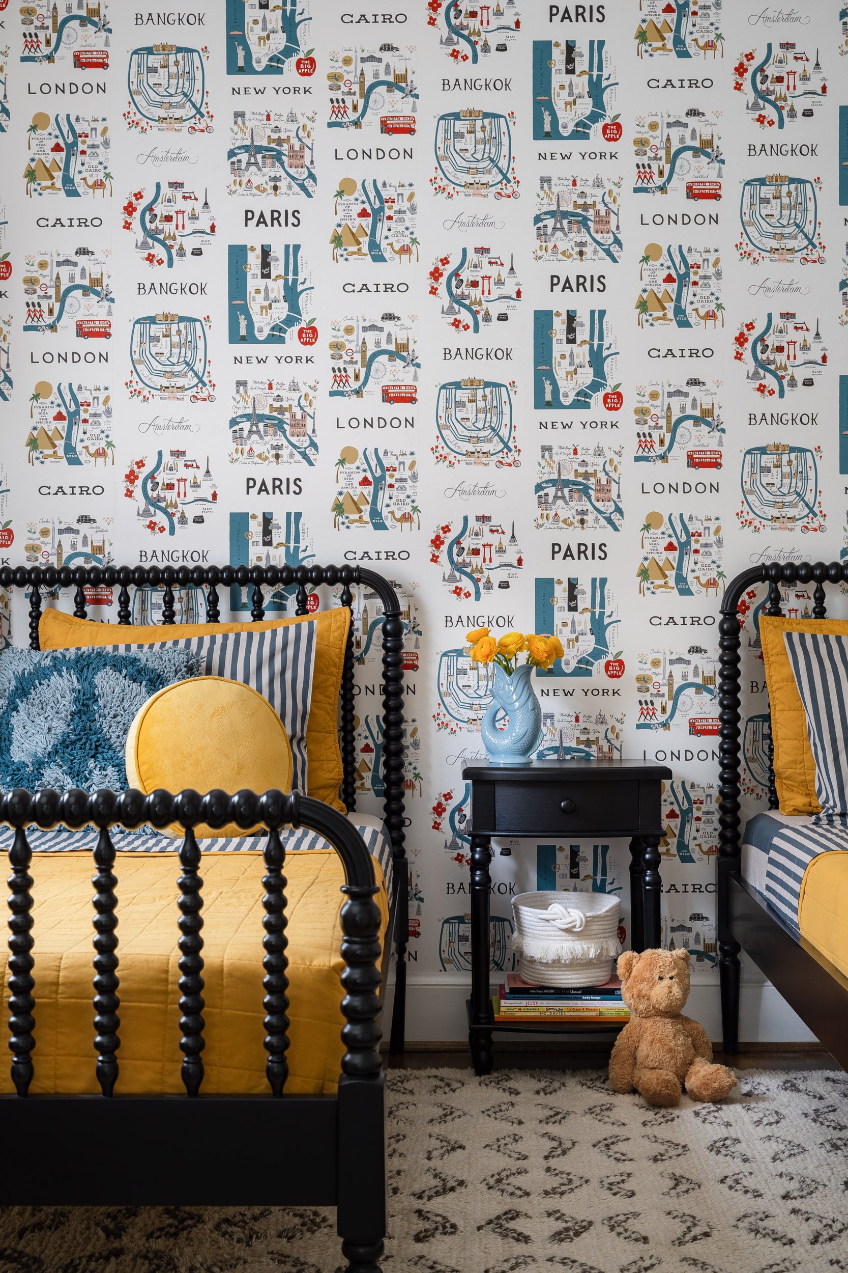 Kids' bedroom with twin spindle beds and world map wallpaper, interior design photography in Maryland