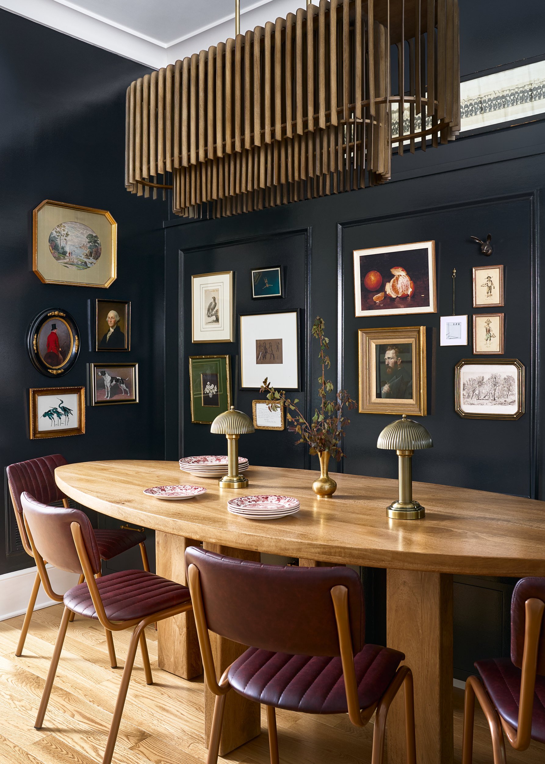 Dining room with navy walls, an oval table, and gallery wall, interior design photography in Washington, DC