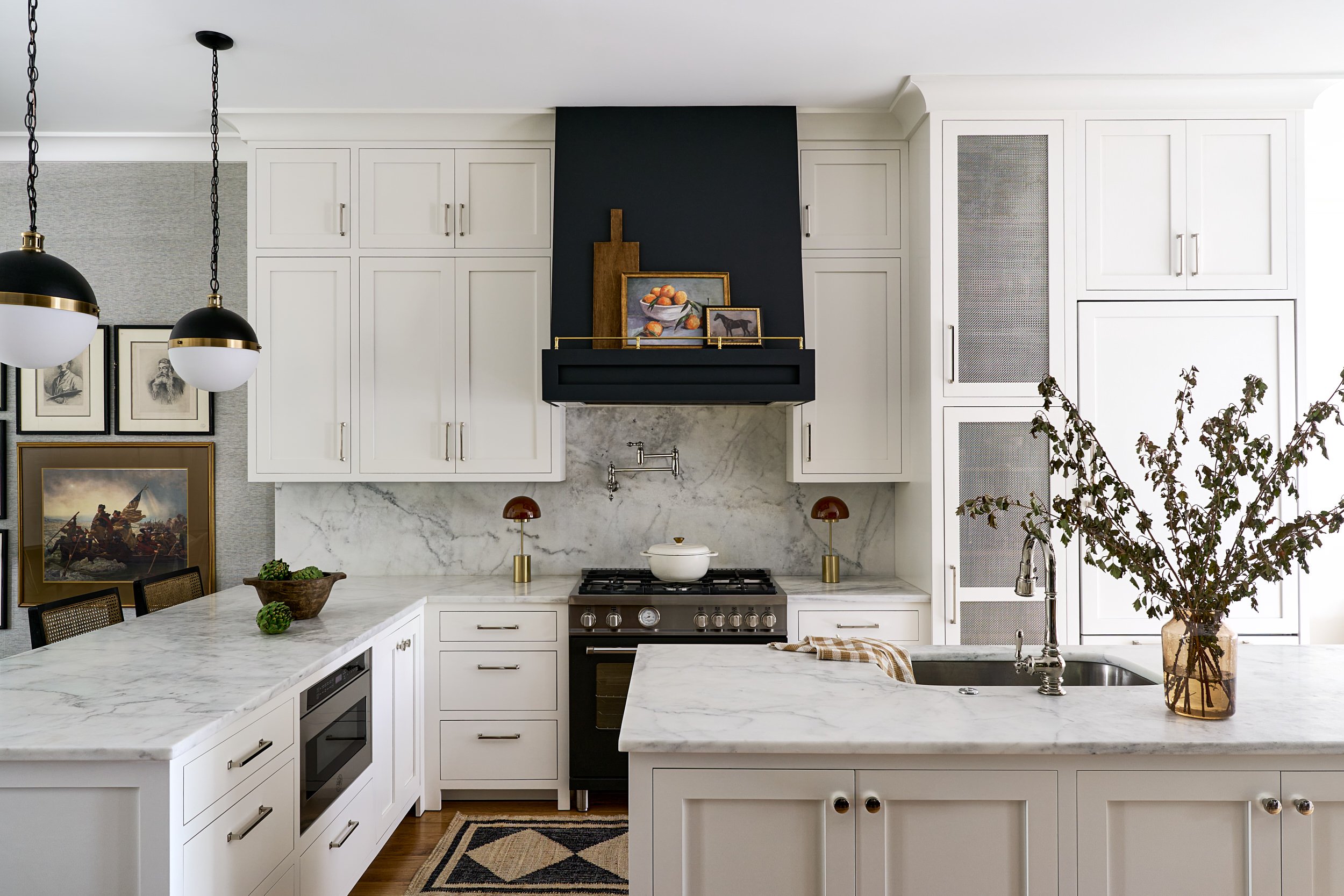 Kitchen with a black range hood, marble backsplash, and black globe pendant lights, interior design photography in Maryland