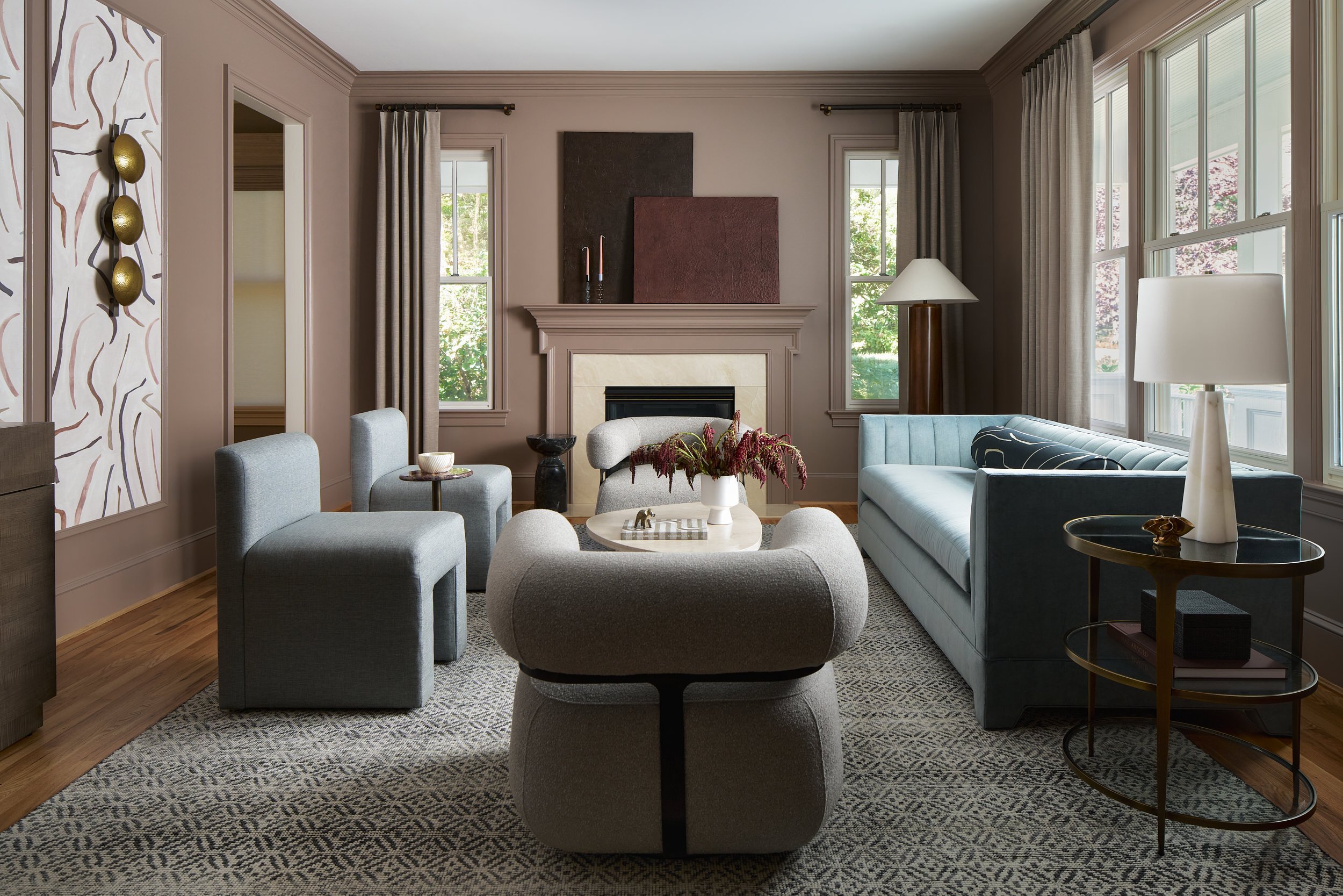 Living room with bouclé swivel chairs, a blue channel-tufted sofa, and a sculptural wall sconce, interior design photography in Northern Virginia