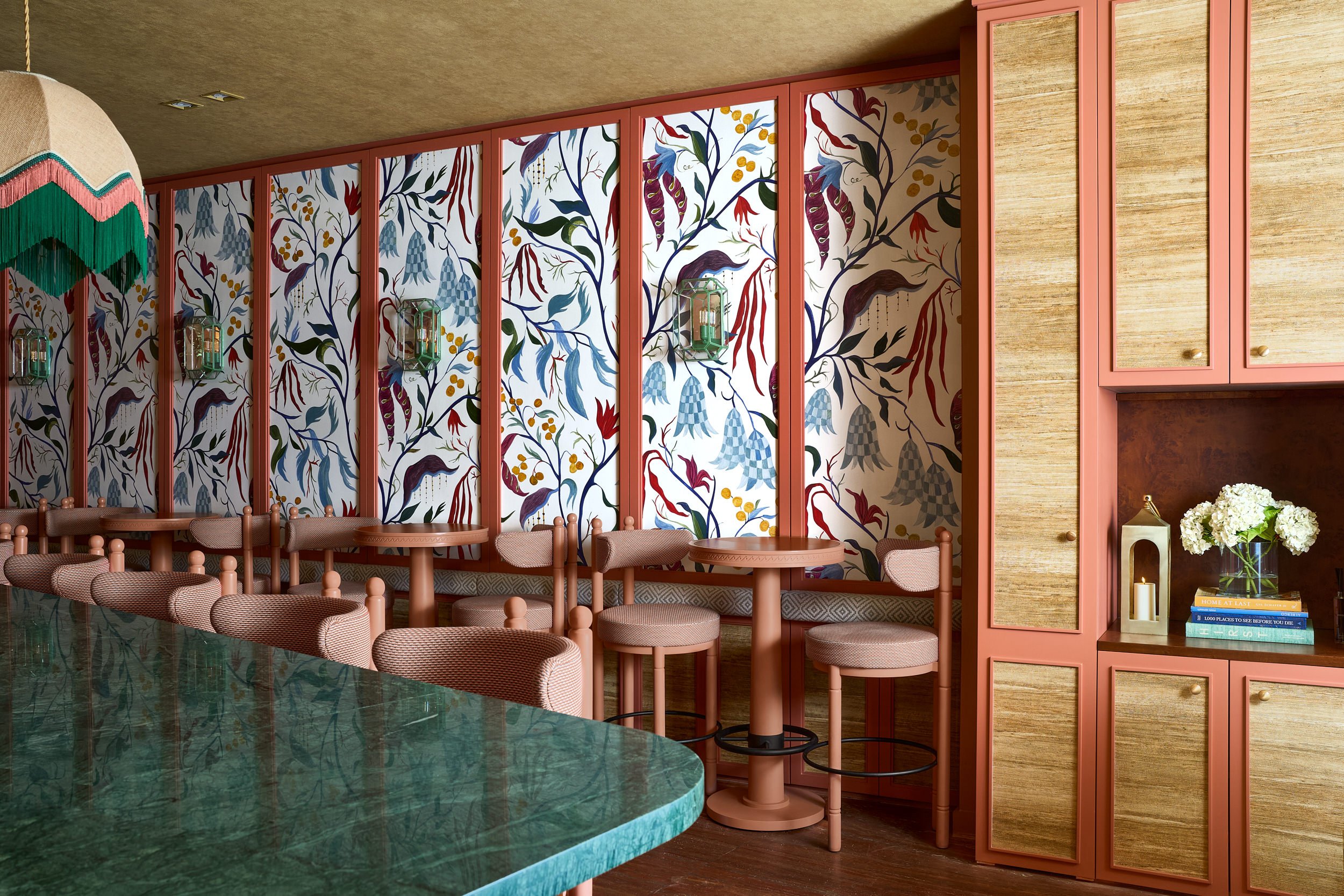 Restaurant bar with a botanical mural, coral banquettes, and a green marble bar top, commercial interior photography, commercial interior photography in Washington, DC