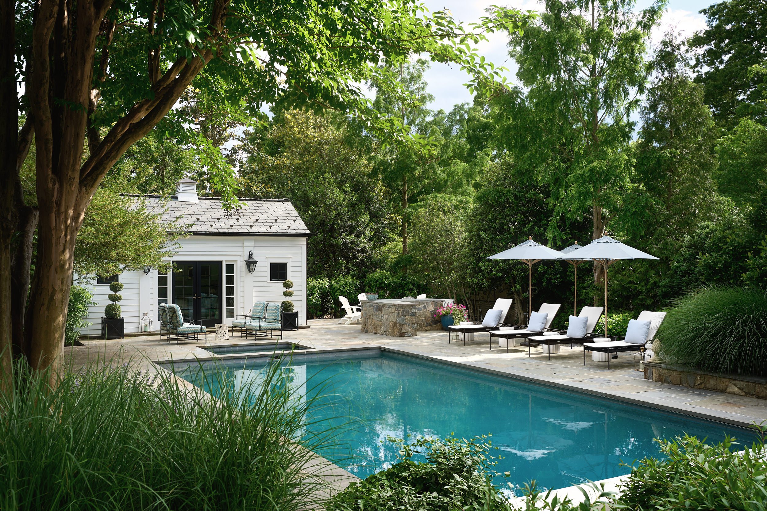 Backyard pool and pool house surrounded by mature landscaping, architectural photography in the DMV area