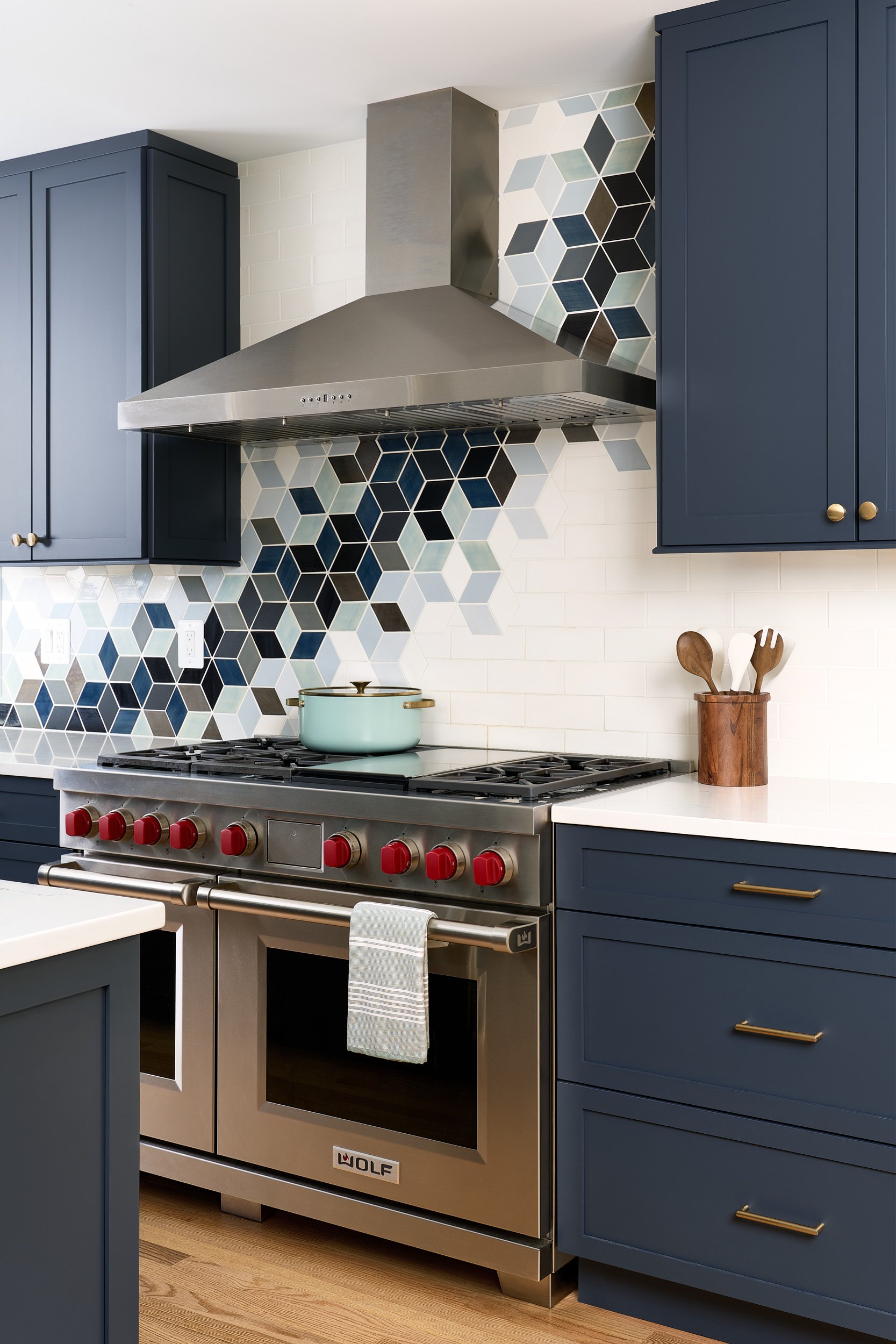 Kitchen with navy cabinetry and a geometric tile backsplash, interior design photography in Maryland