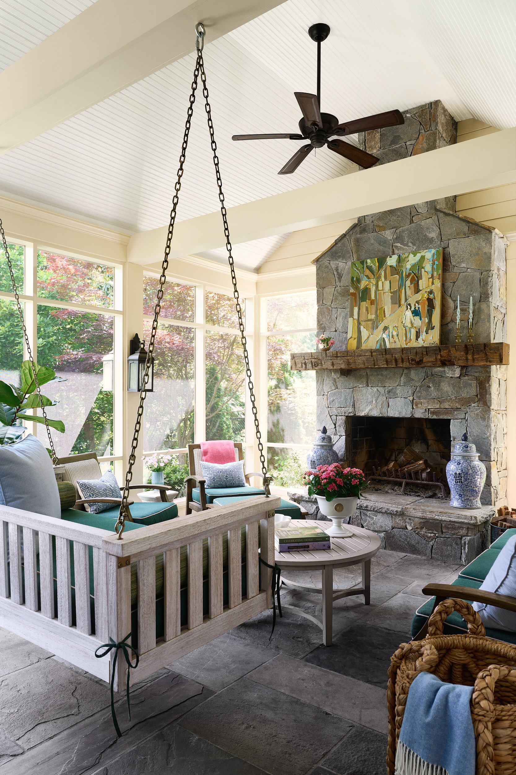 Screened porch with a stone fireplace and hanging daybed swing, architectural photography in Northern Virginia