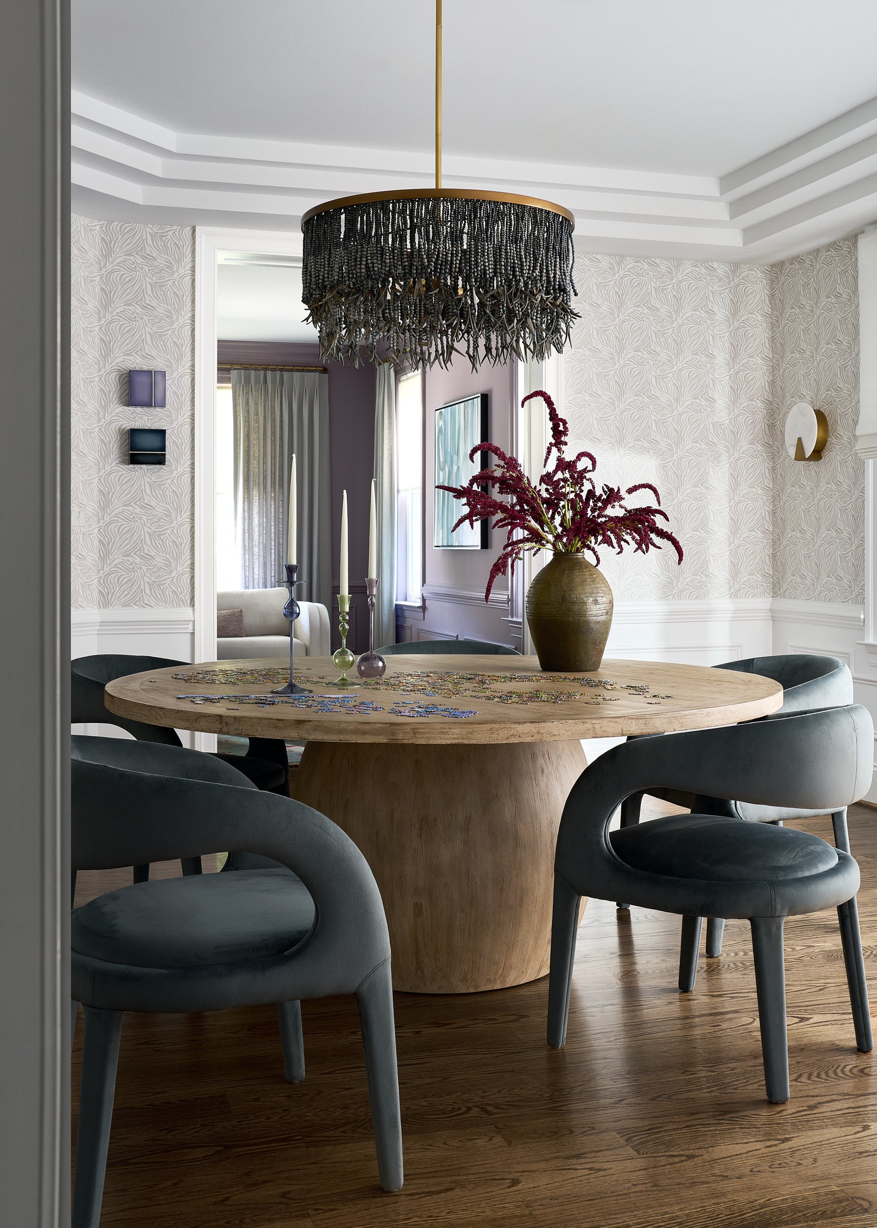 Dining room with a round wood table and fringe chandelier, interior design photography in Northern Virginia