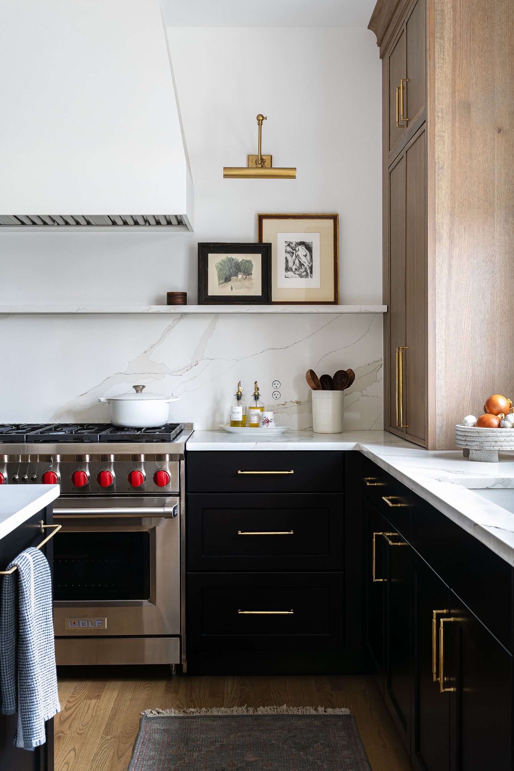 Kitchen with black cabinetry, a range, and marble backsplash, interior design photography in Washington, DC