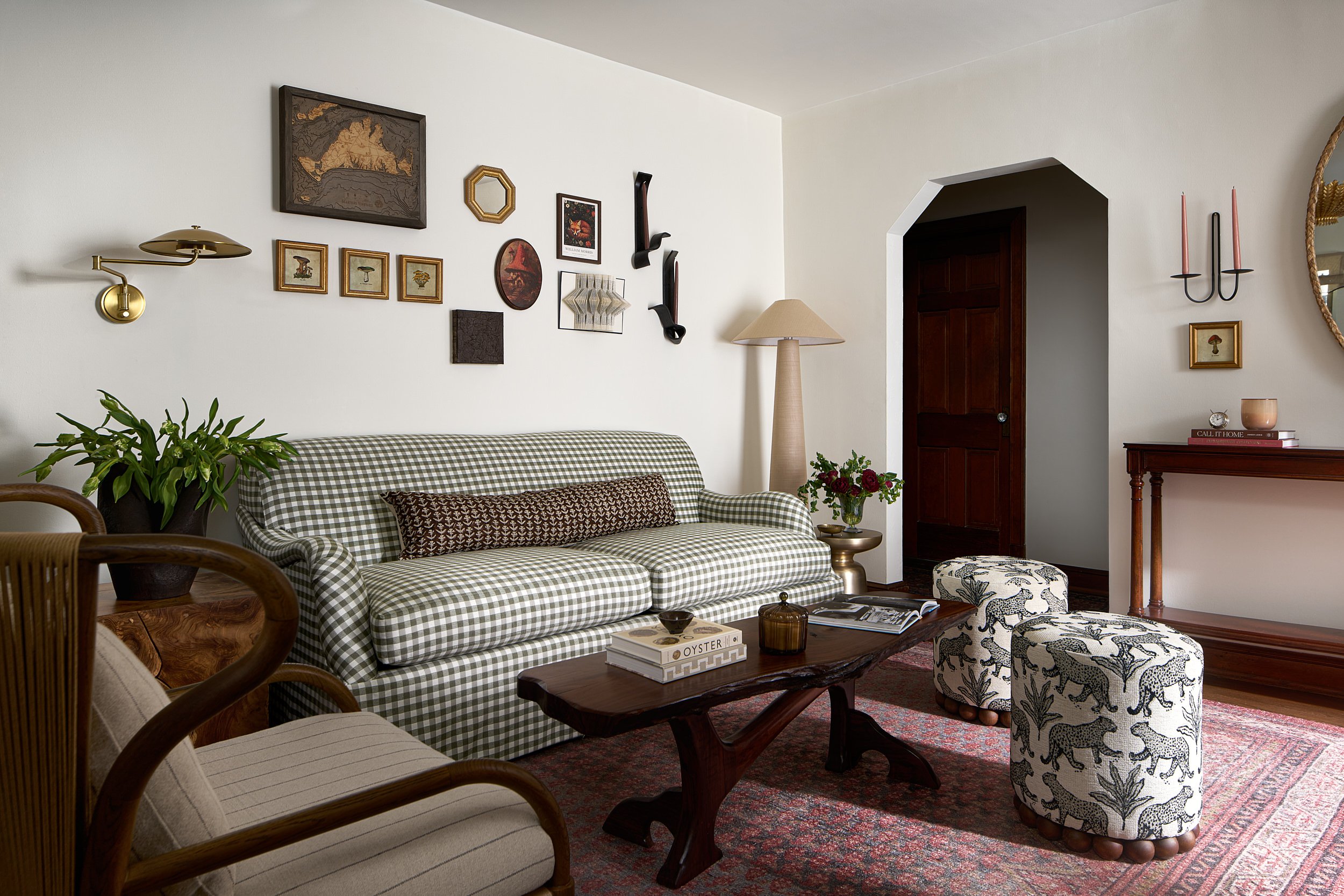 Living room with a gingham check sofa, leopard print ottomans, and an arched doorway, interior design photography in Northern Virginia