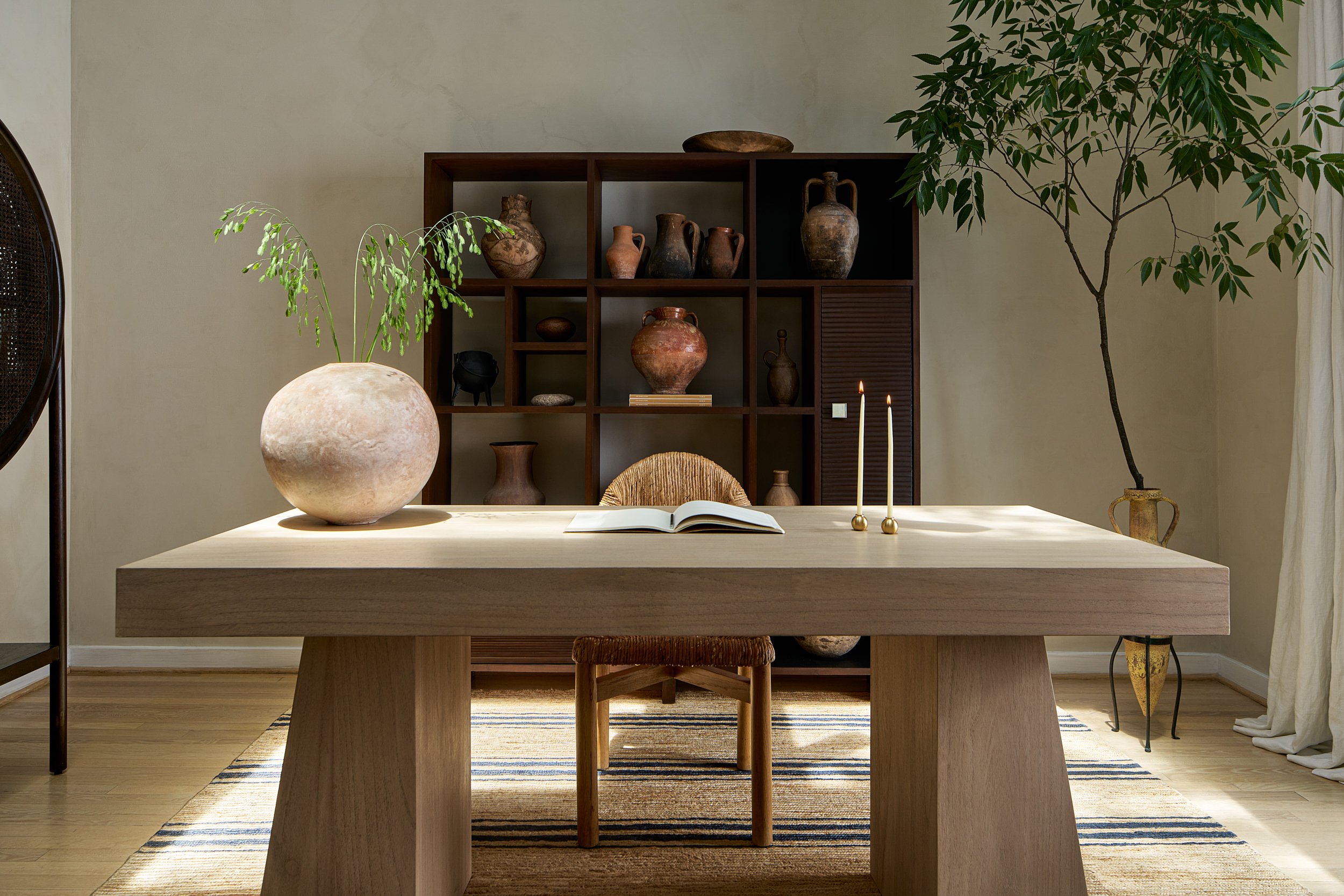 Dining room vignette with a round pottery vase and dark wood cabinet, interior design photography in the DMV area