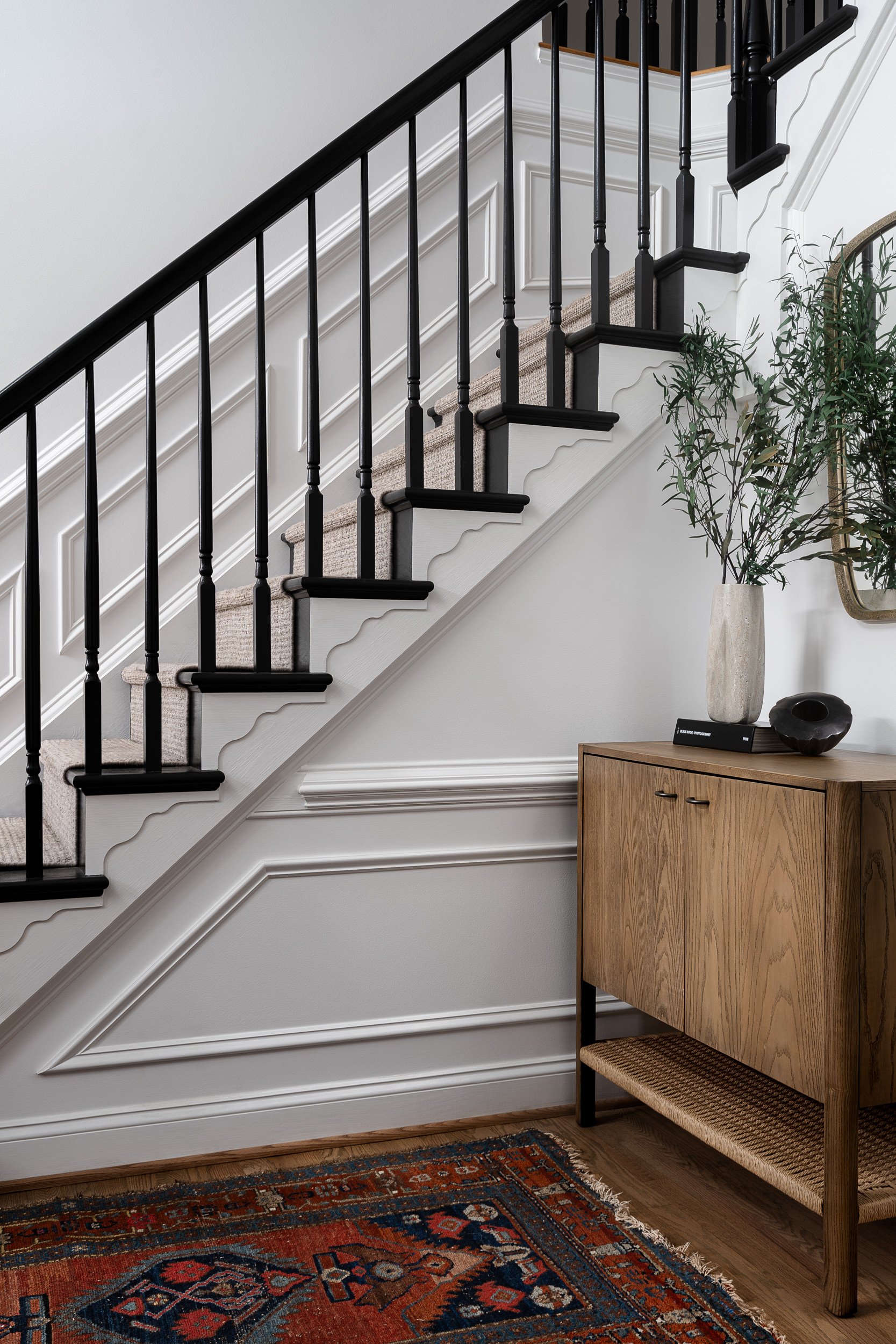 Staircase with scalloped stair treads and a wood console table, interior design photography in the DMV area