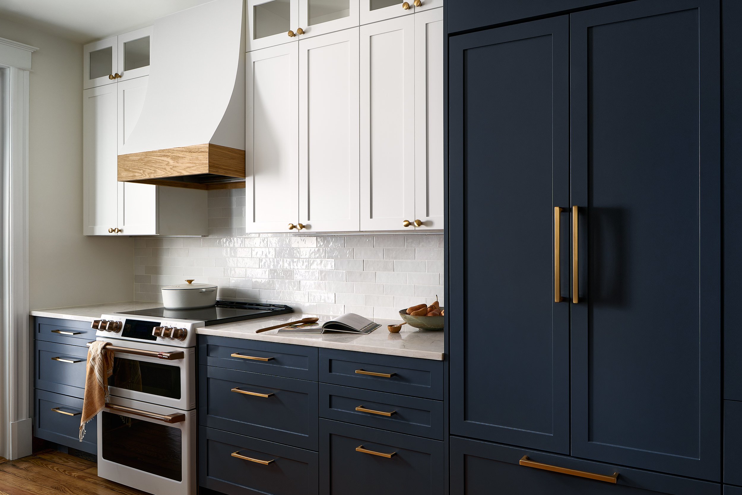 Kitchen with navy lower cabinets, white upper cabinets, and brass hardware, interior design photography in Northern Virginia