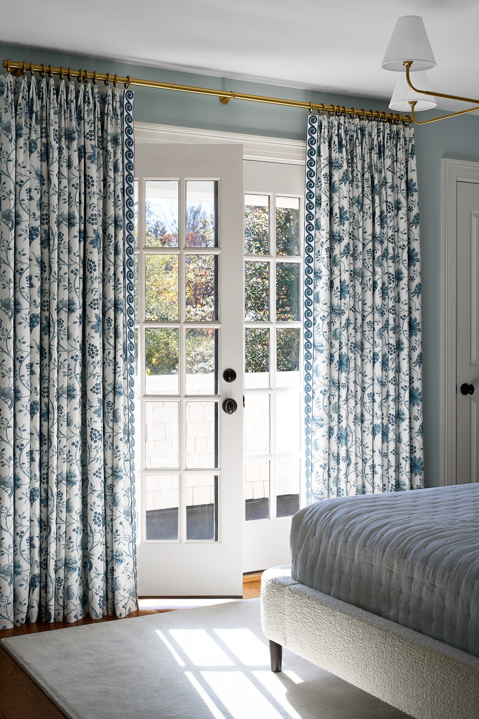Bedroom with floral drapery framing French doors, interior design photography in Washington, DC