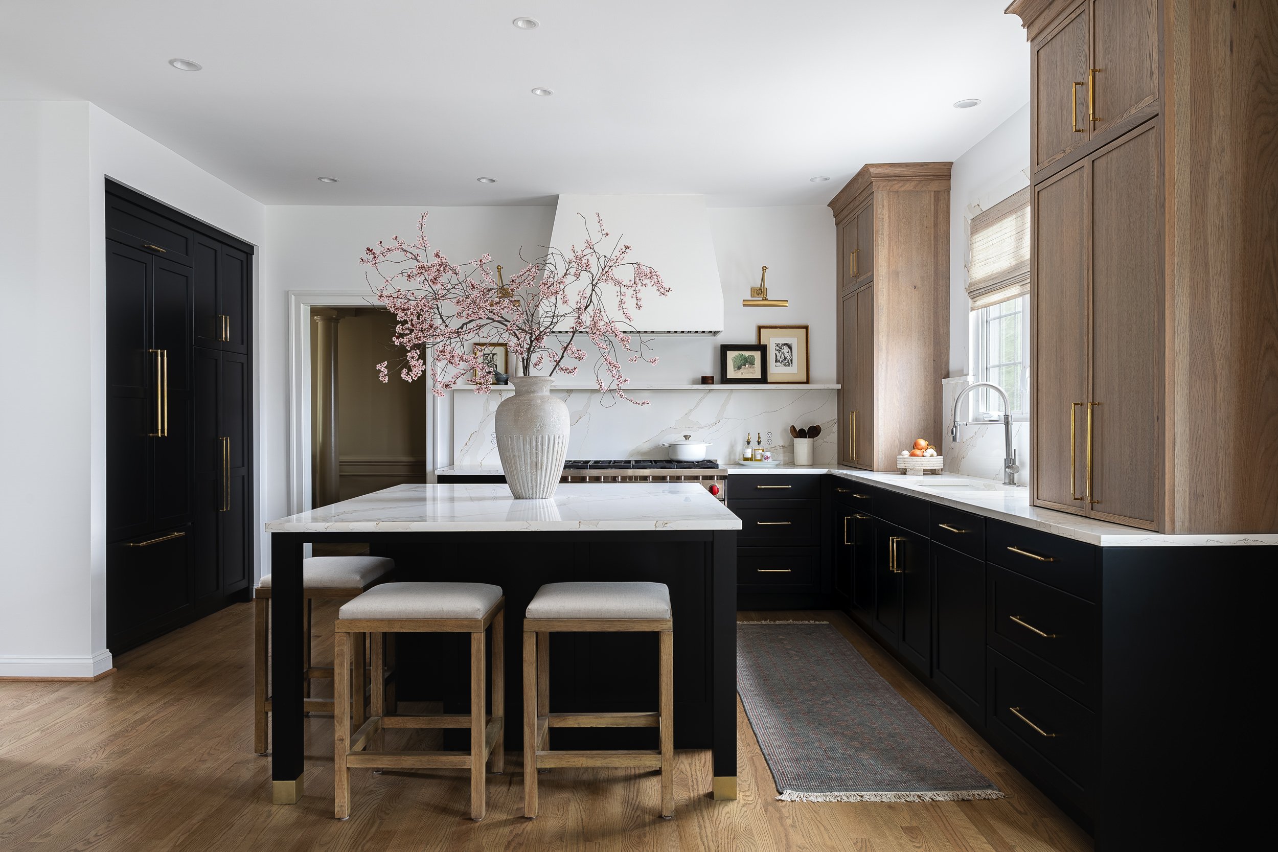 Kitchen with black cabinetry, wood accents, and a large island, interior design photography in Northern Virginia