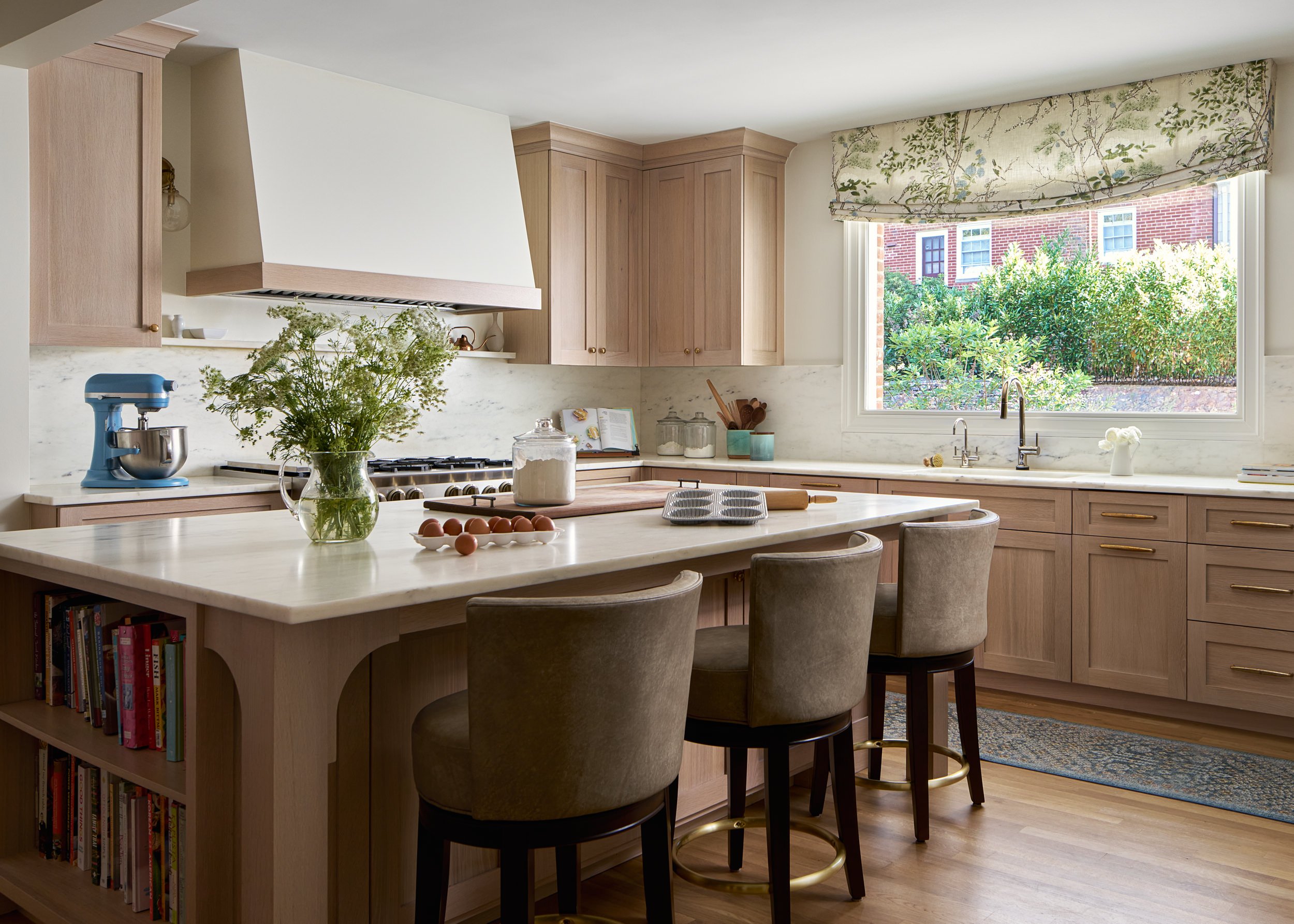 Kitchen with blush pink cabinetry and a floral roman shade, interior design photography in the DMV area
