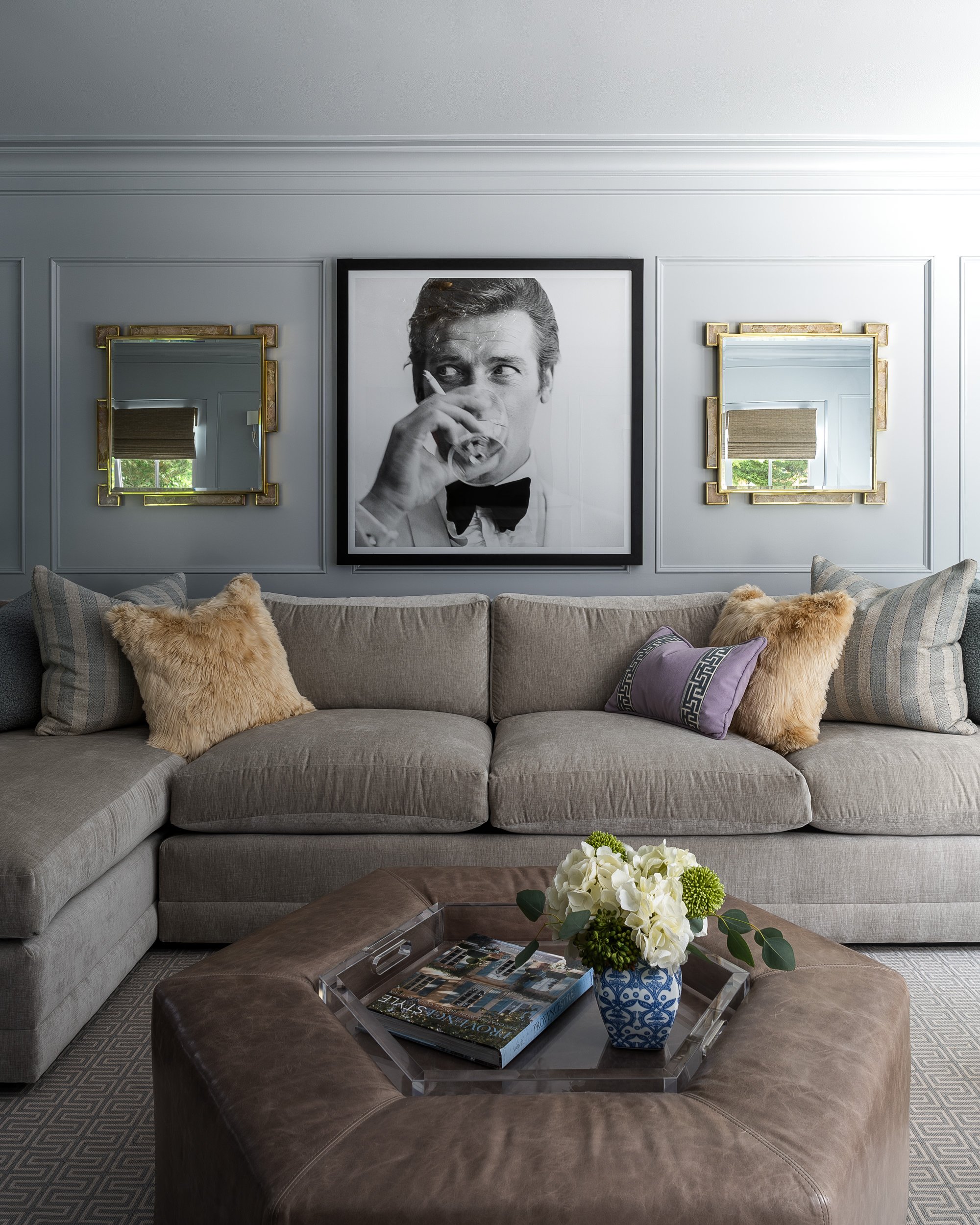 Living room with a gray sectional sofa and gold mirrored accents, interior design photography in Maryland