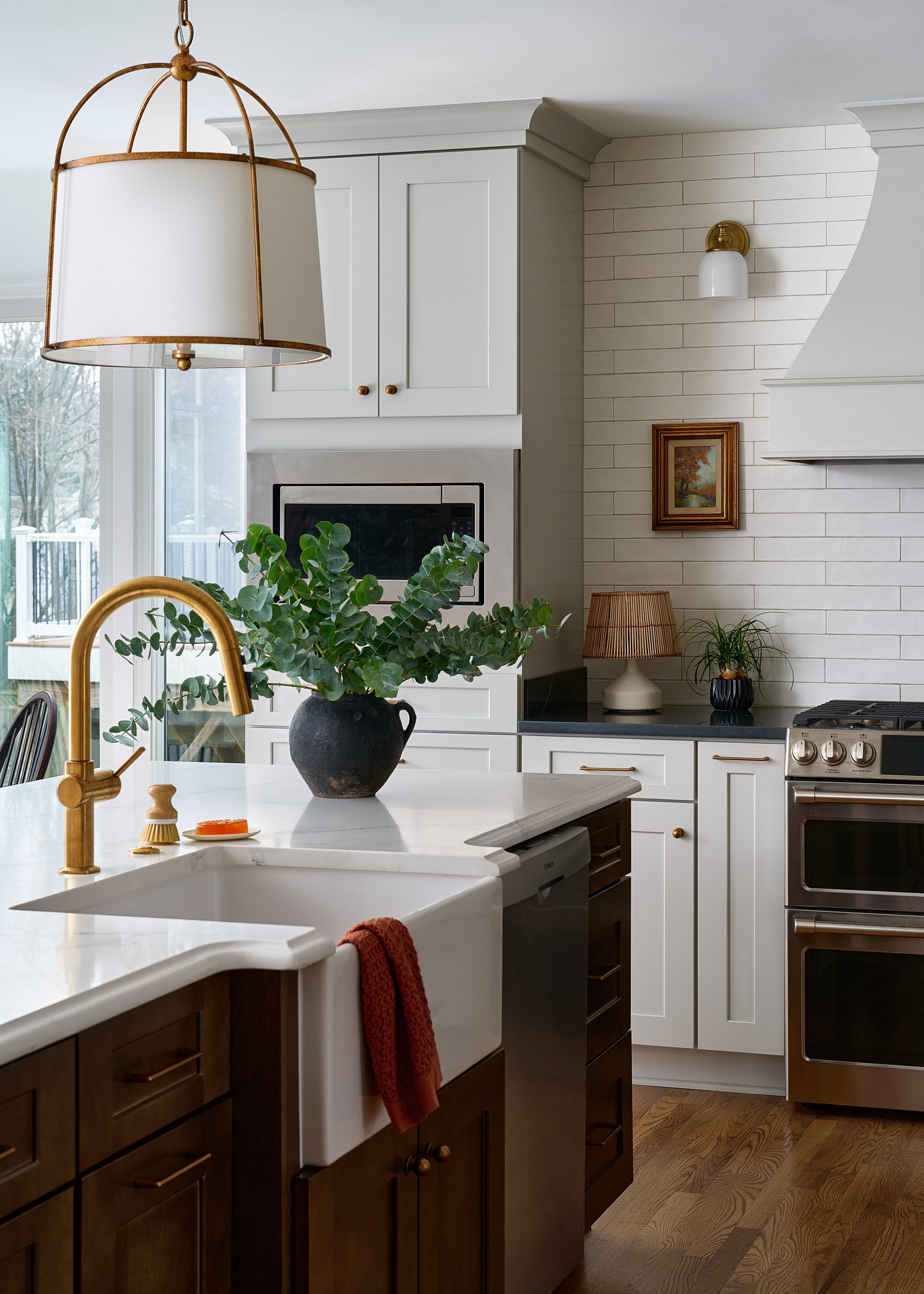 Kitchen with a brass pendant light and subway tile range hood, interior design photography in the DMV area