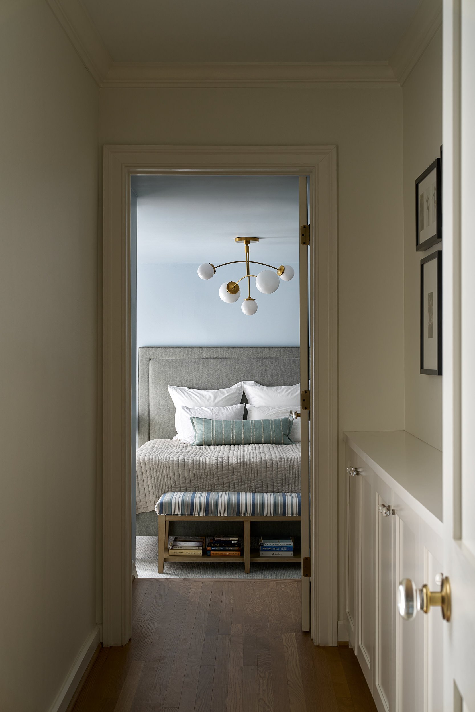 Hallway leading to a bedroom beneath a globe chandelier, interior design photography in Maryland