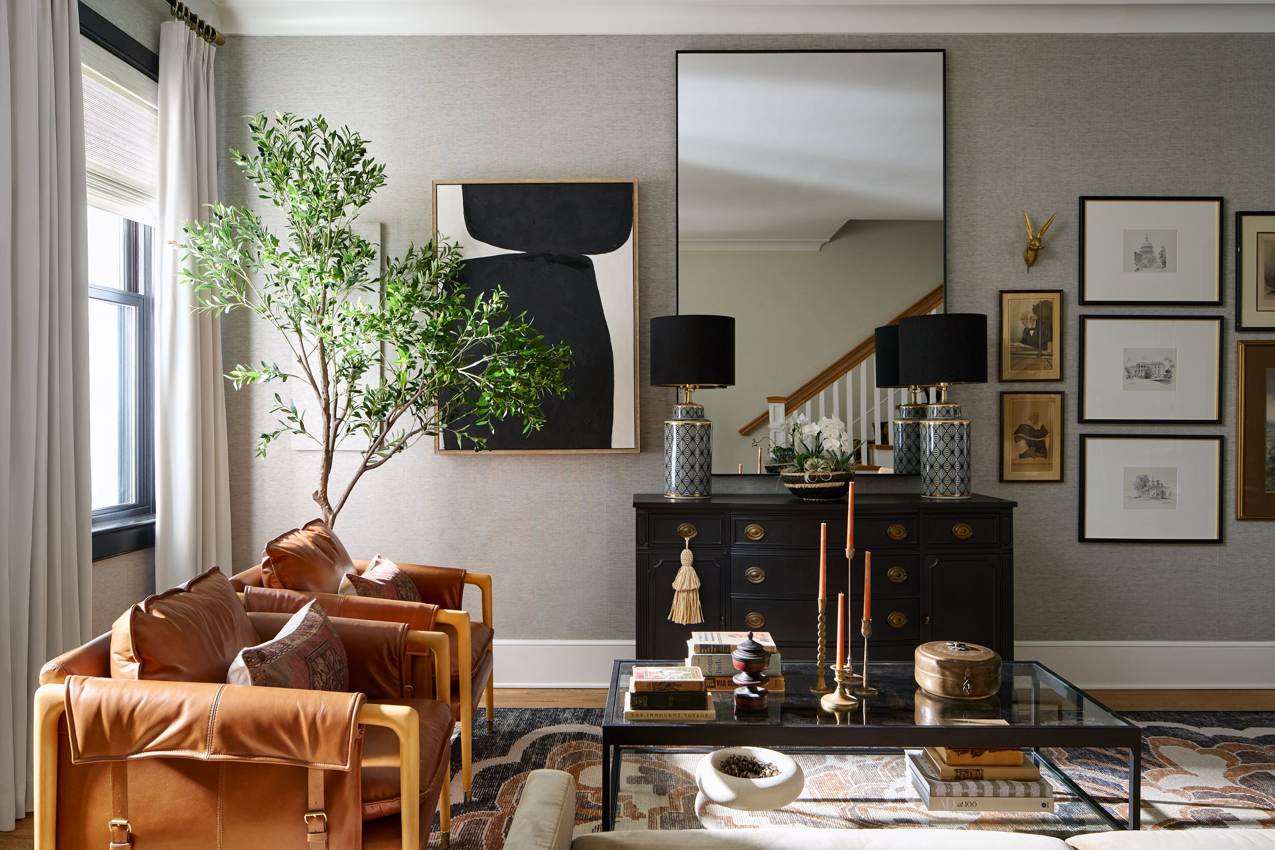 Living room with leather armchairs, a black console, and gallery wall, interior design photography in Washington, DC