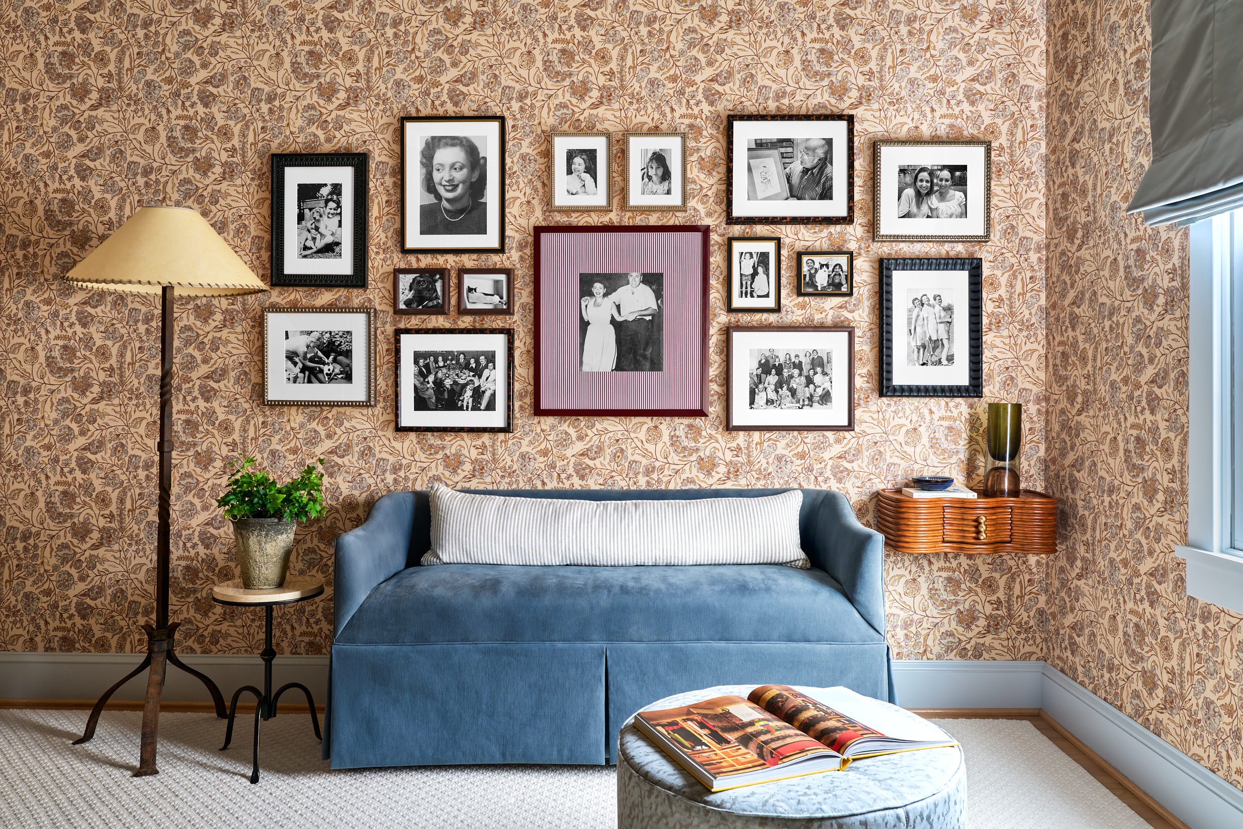 Living room with botanical wallpaper, a vintage black-and-white photo gallery wall, and a blue velvet daybed, interior design photography in Washington, DC
