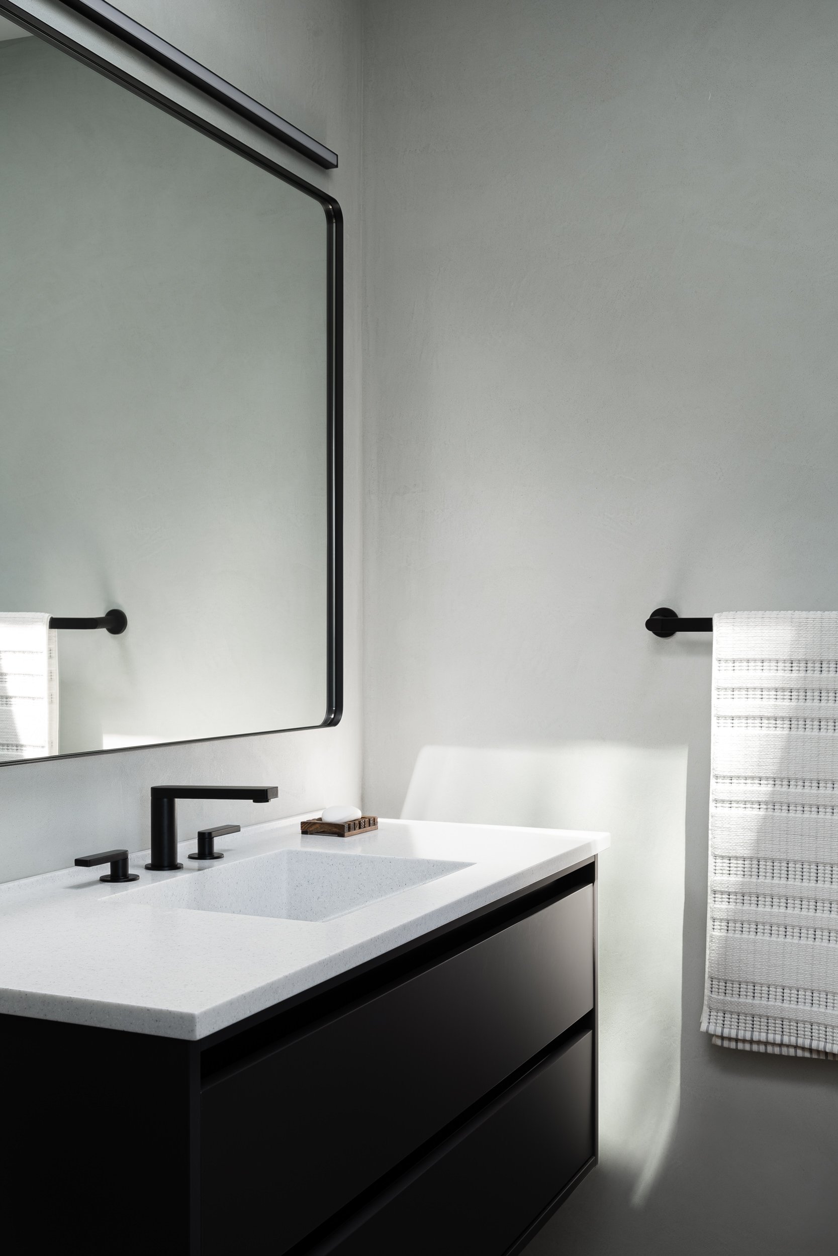 Modern bathroom with a matte black vanity and white quartz countertop, interior design photography in the DMV area