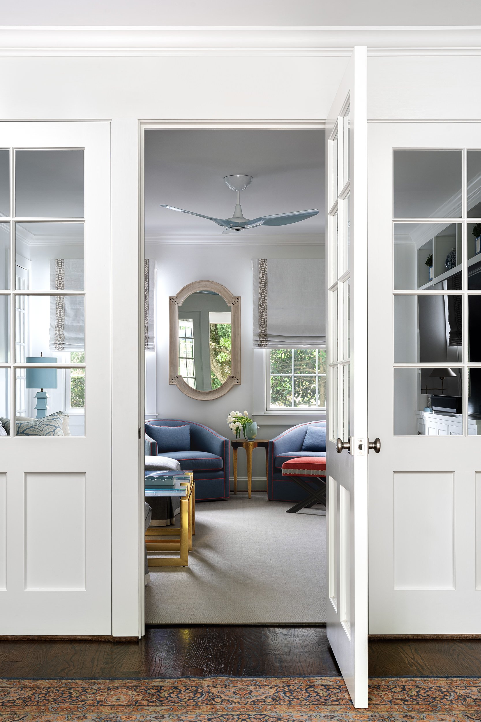French doors opening to a sunroom with blue armchairs, interior design photography in Washington, DC
