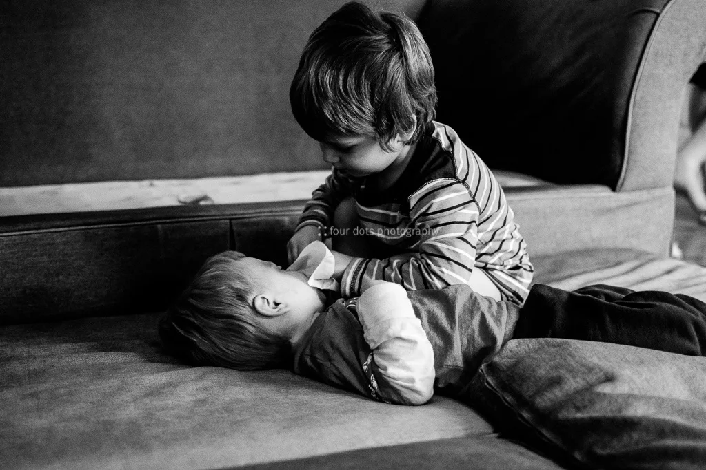 love is offering to wipe little brother's nose for him.