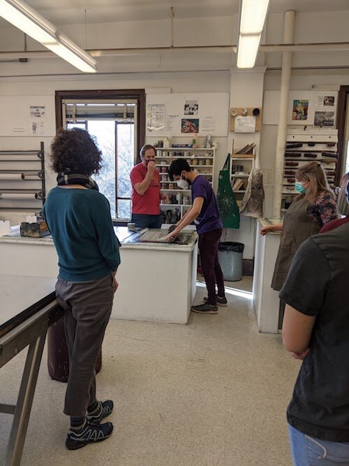  Students watch how to ink a block with the large roller. 