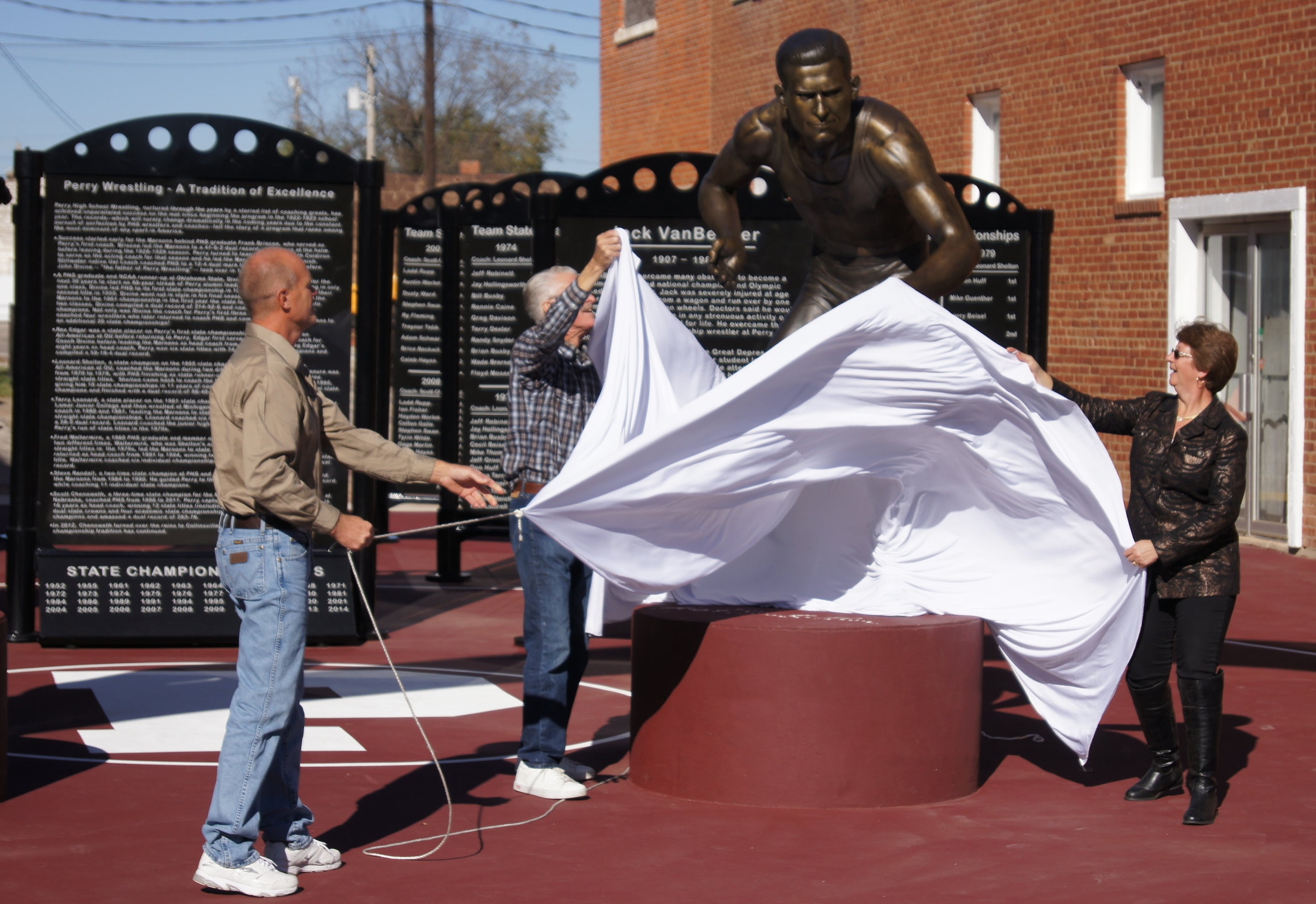 Ben and Kay Passow and Richard VanBebber unveil the statue of Jack VanBebber.