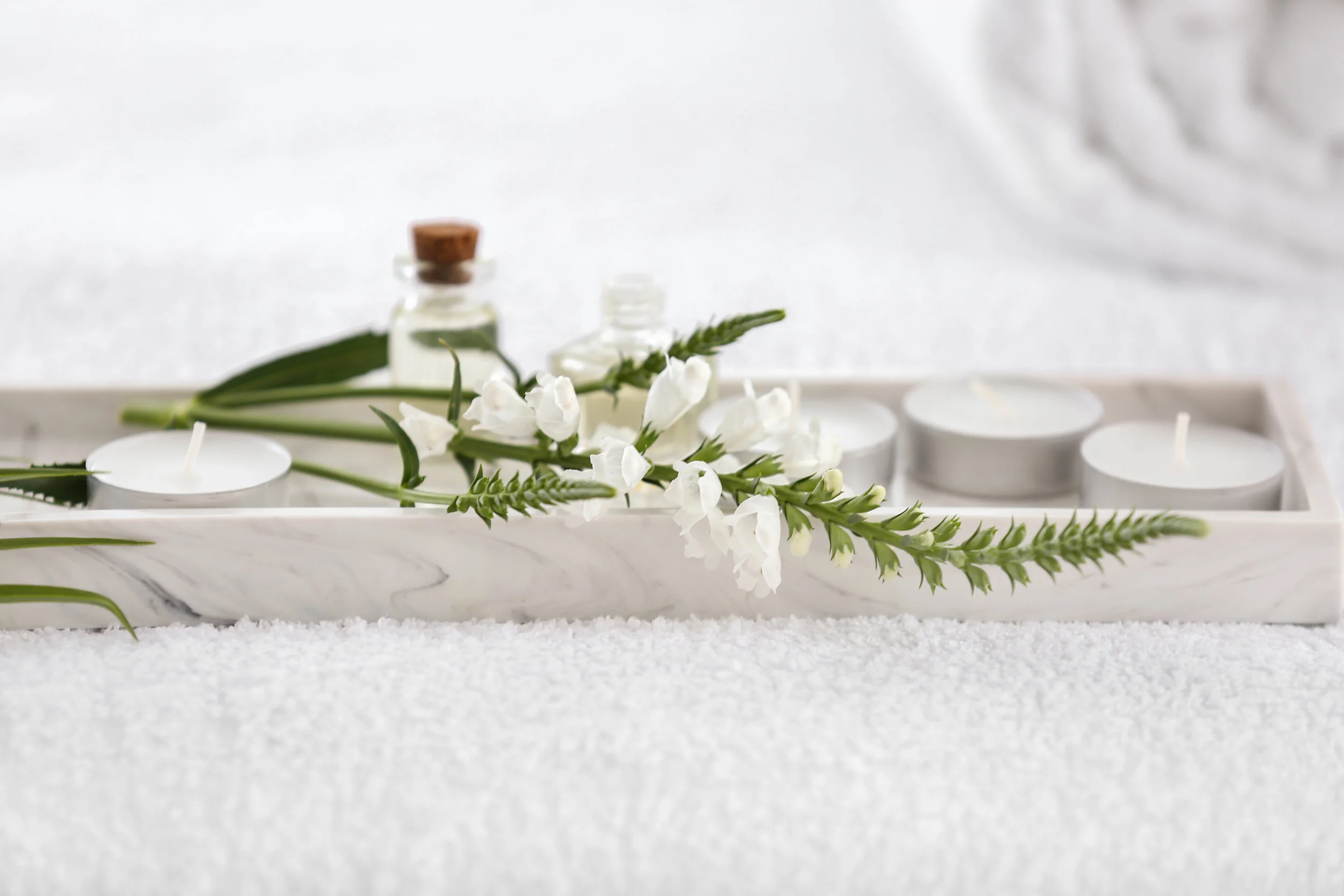 Flowers and spa items on table in beauty salon