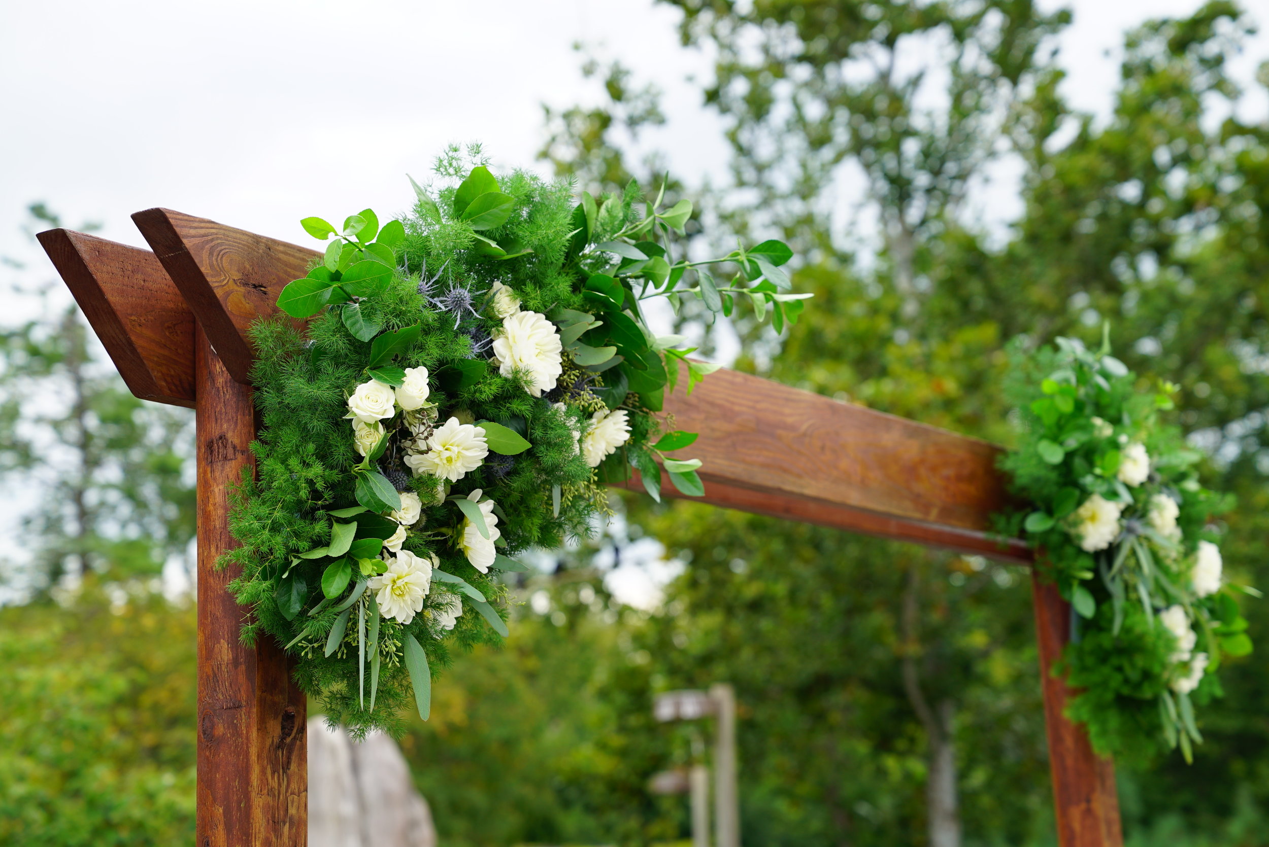  The arch was built using landscaping beams, then stained to match the wood on location. We sunk the uprights into concrete (poured into decorative pots) since the ceremony was on a wooden deck and we had no other way of anchoring the arch into the g