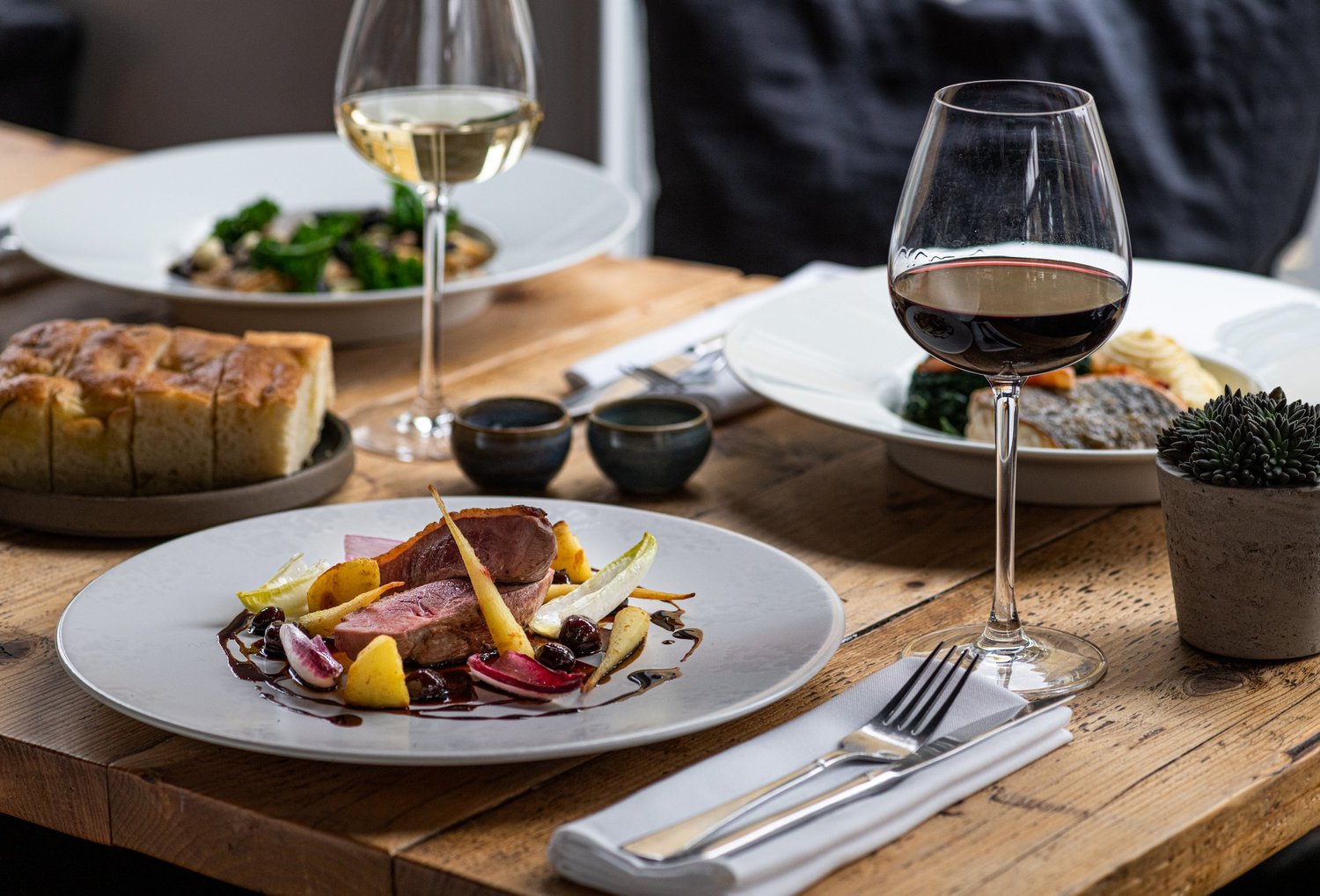 Seasonal dishes and wine on a table at Salut