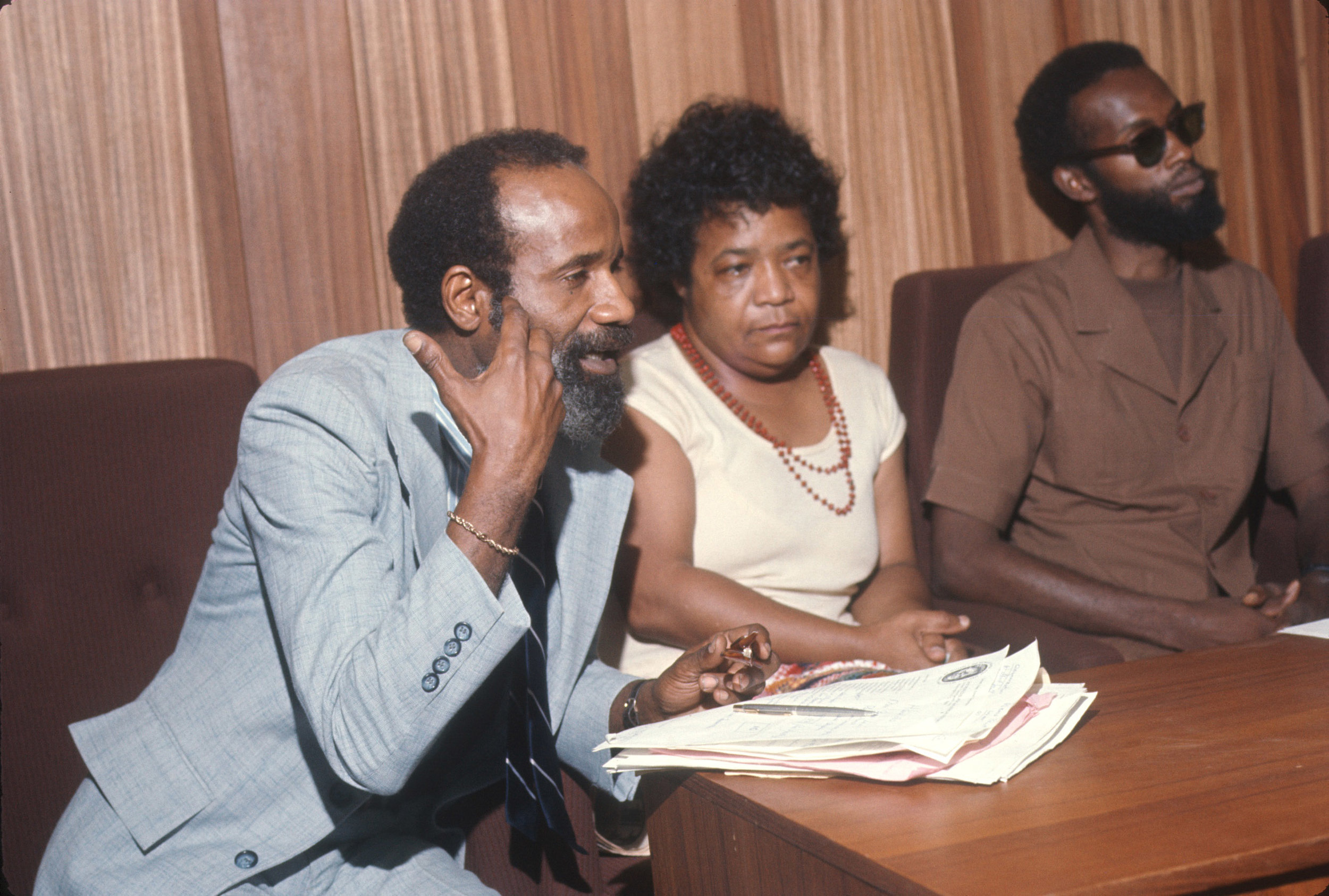 Historian Lerone Bennett Jr. in blue suit., artists Samella Lewis, and Ed Spriggs, artist and curator.