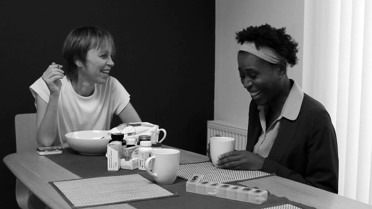 Awake+still_+two+women,+one+white+and+one+black,+laugh+over+coffee.jpeg