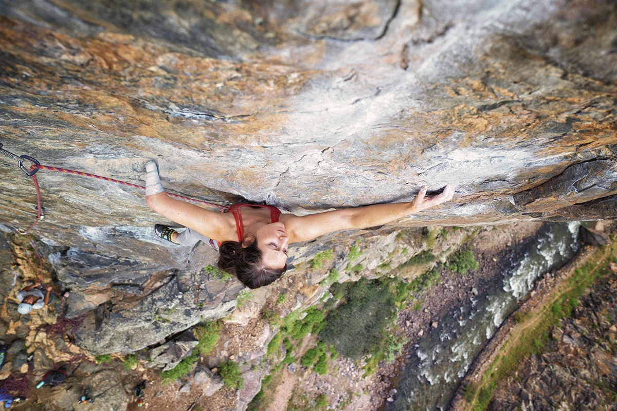 Maureen climbs a sheer rock-face, hundreds of feet in the air.