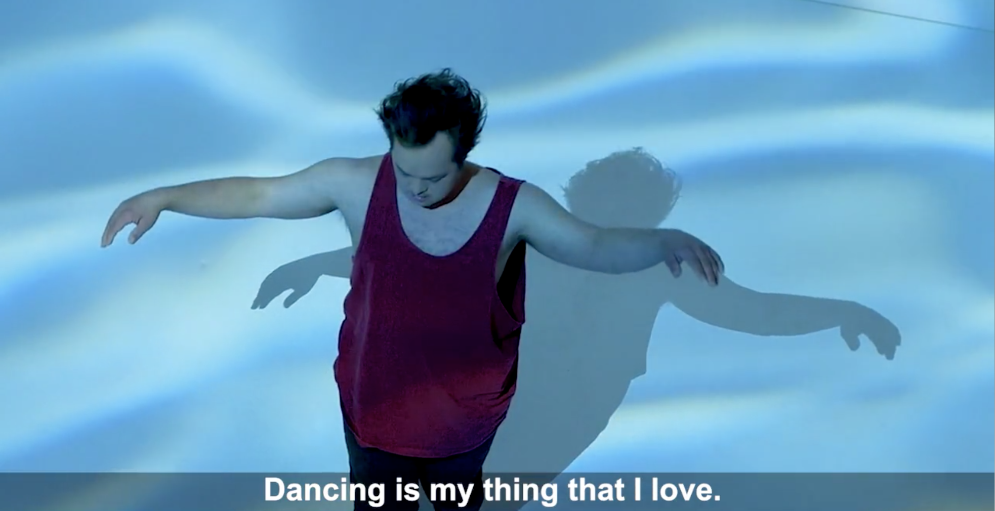 A boy dances in front of lights which mimic water, and below, subtitle: "Dancing is my thing that I love."