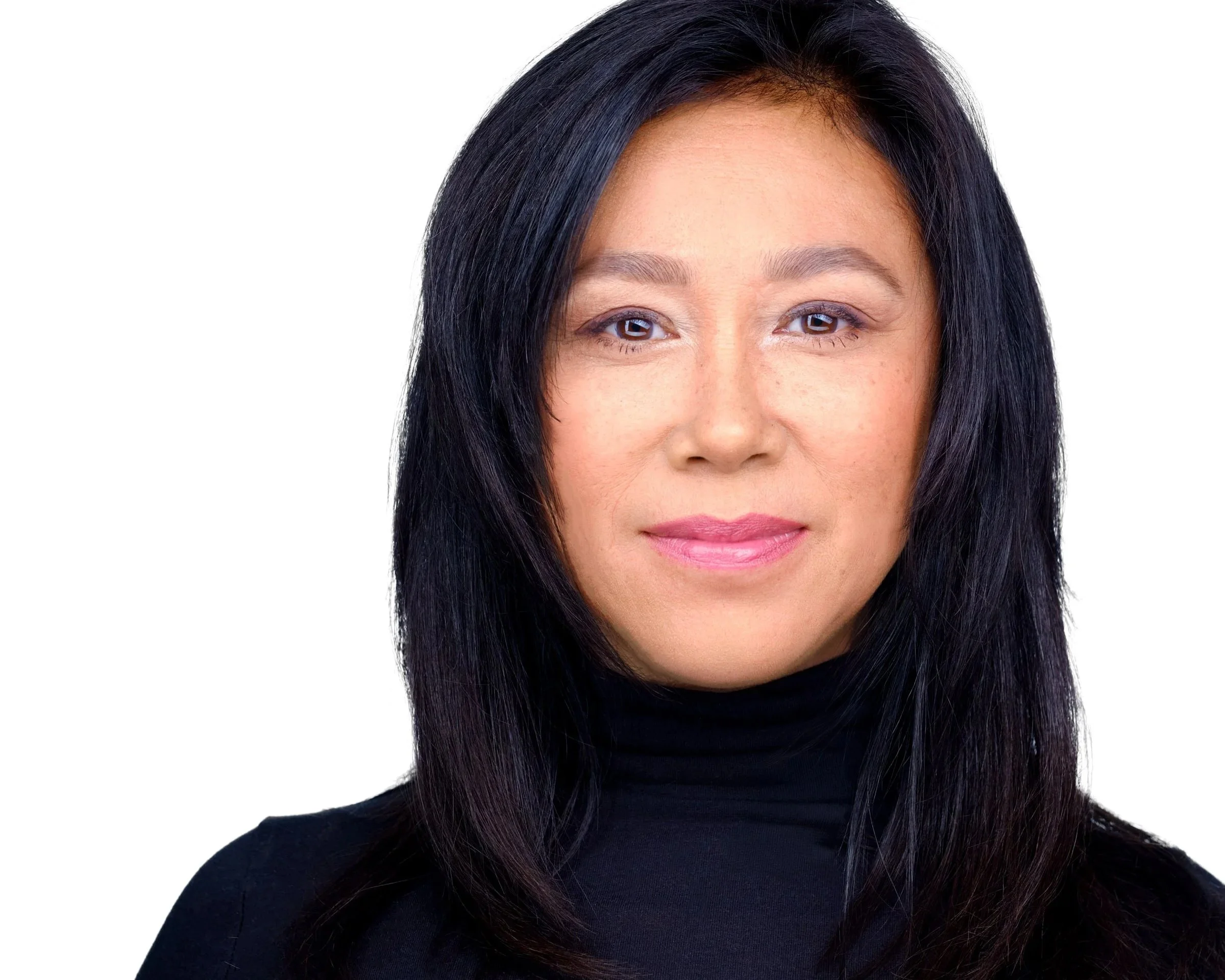 Close-up photo of a woman with dark hair, wearing a black turtleneck. Only the upper half of her face is visible, showing her forehead, eyes, nose, and mouth.