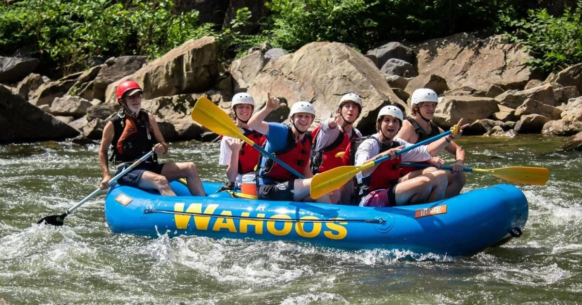 Row of bright green inflatable rafts lined up in front of the Wahoos Adventures outpost