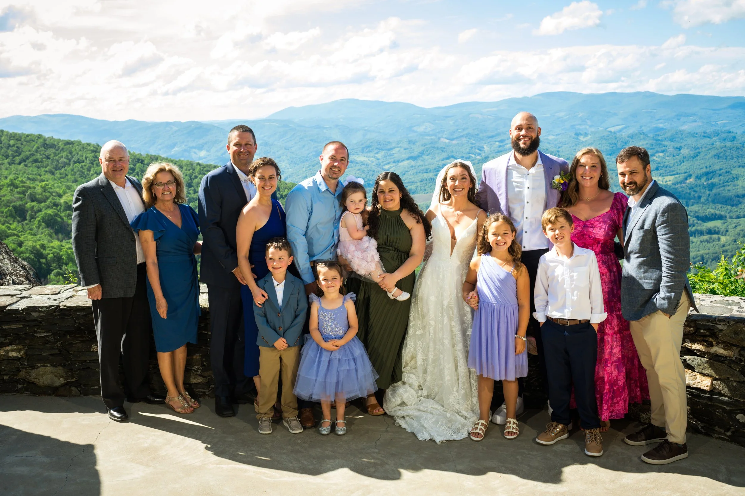 Large family wedding portrait with bride and groom at a mountain overlook with scenic blue ridge views