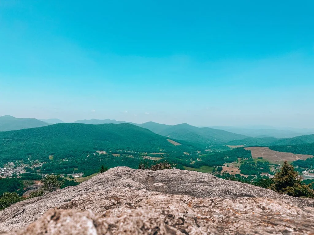 Panoramic mountain view from a rocky summit overlooking valleys and distant ridgelines
