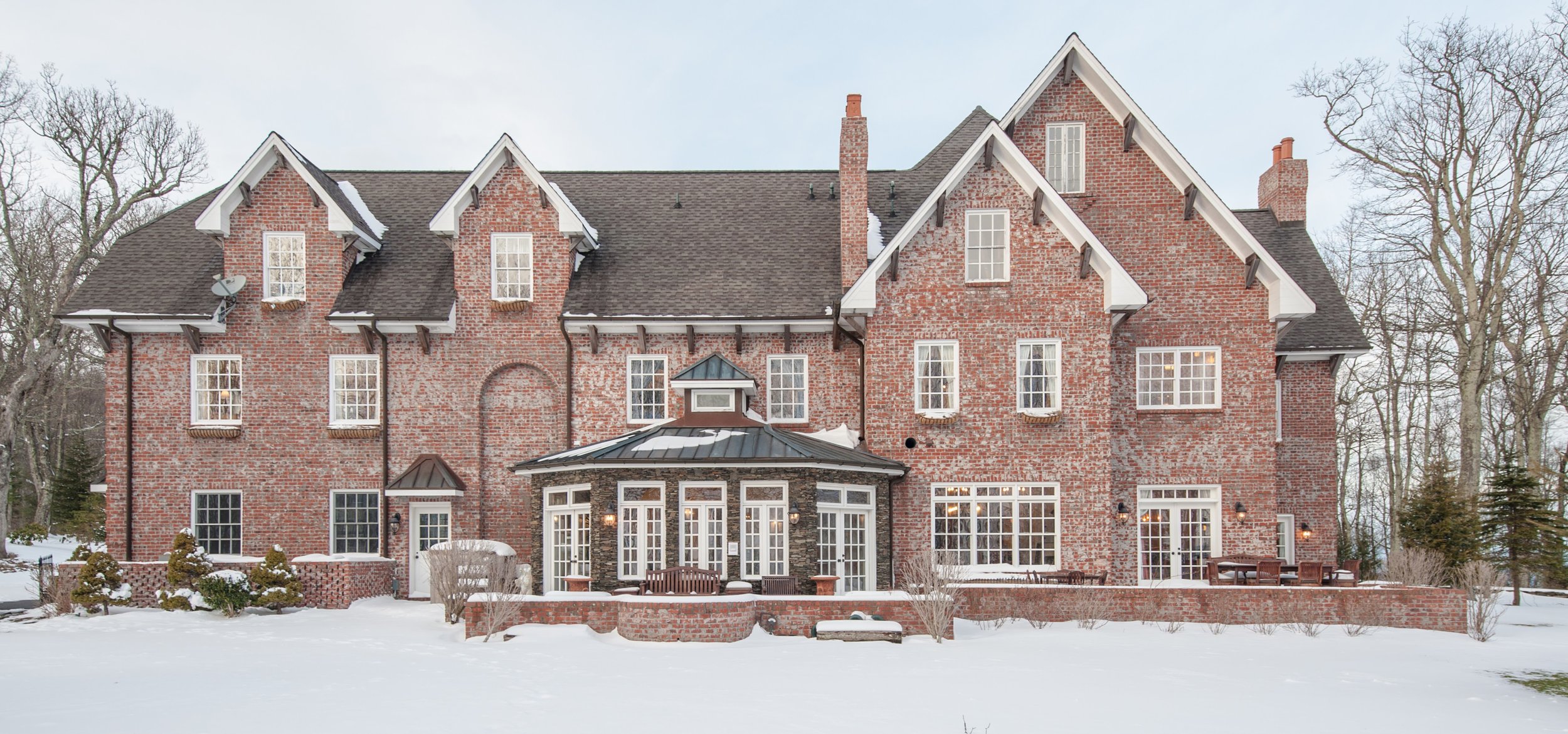  The back of Twickenham House in the winter. Snow covers the lawn and is sprinkled atop the roof of the house. 