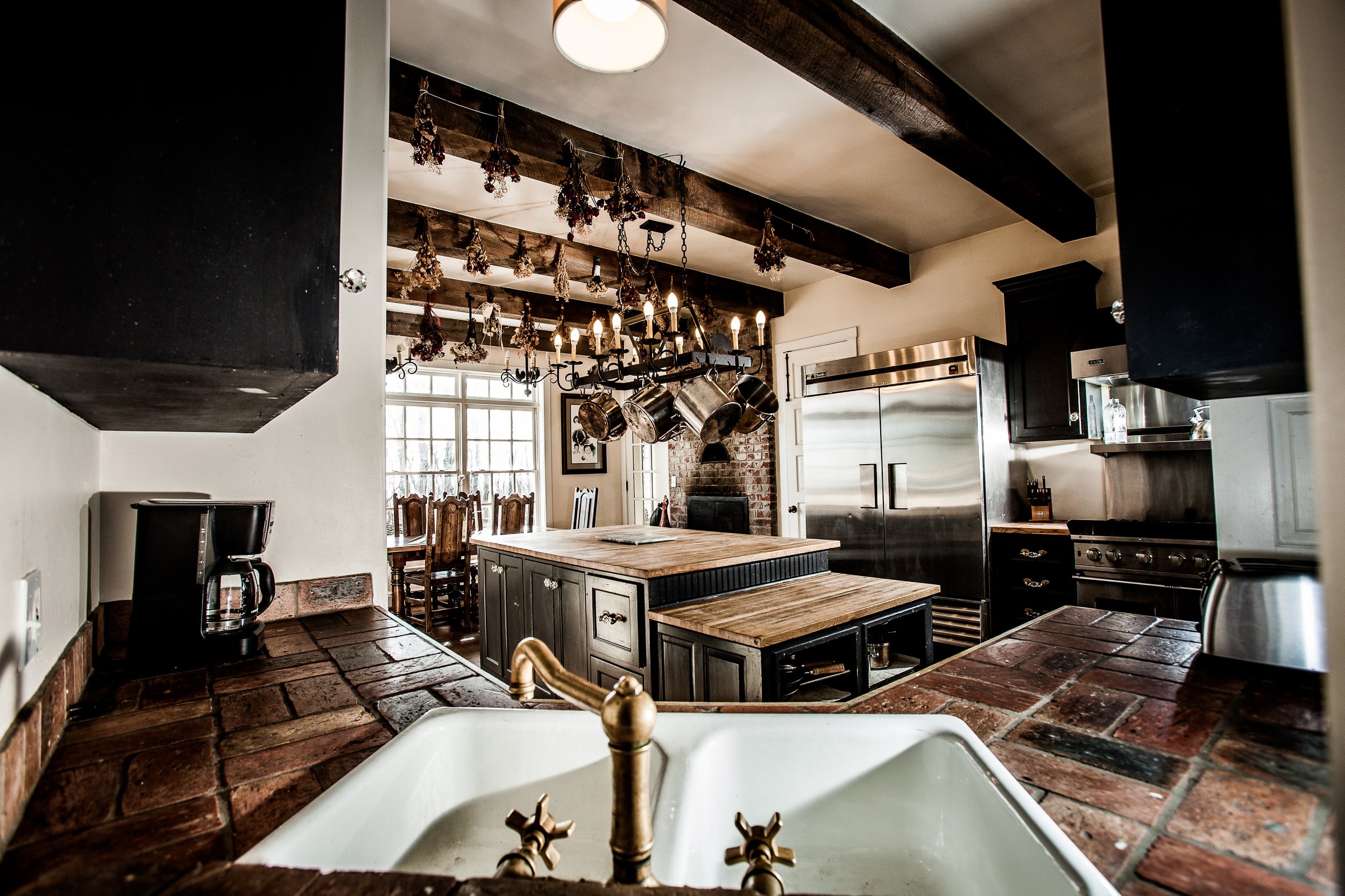  A farm style kitchen sink surrounded by warm, aged tile.  