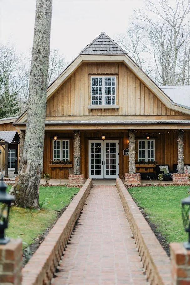 Rustic cabin wedding venue exterior with a brick walkway leading to the front doors