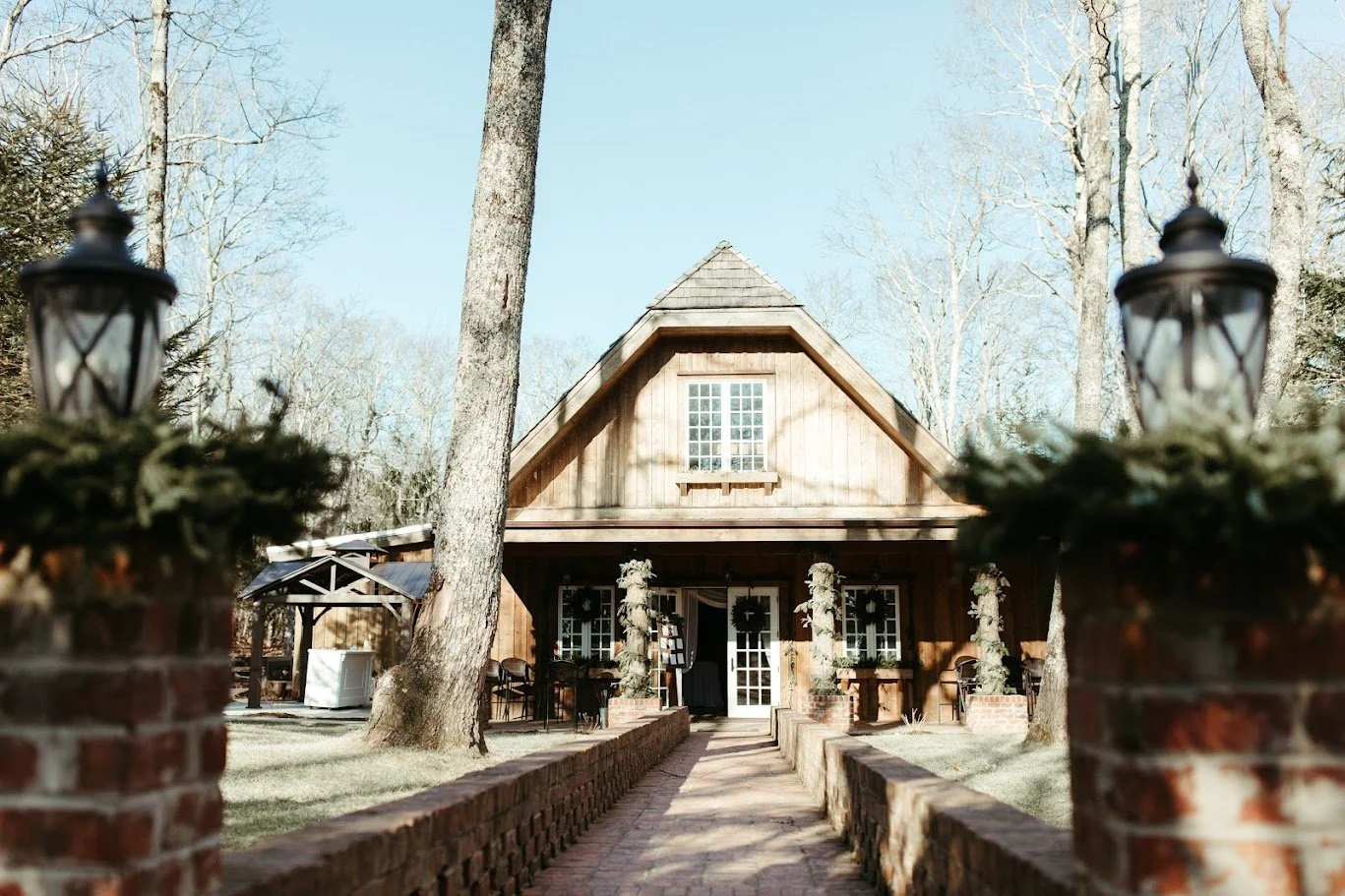 Outdoor mountain wedding venue with a wooden chapel-style ceremony structure and floral aisle decor.