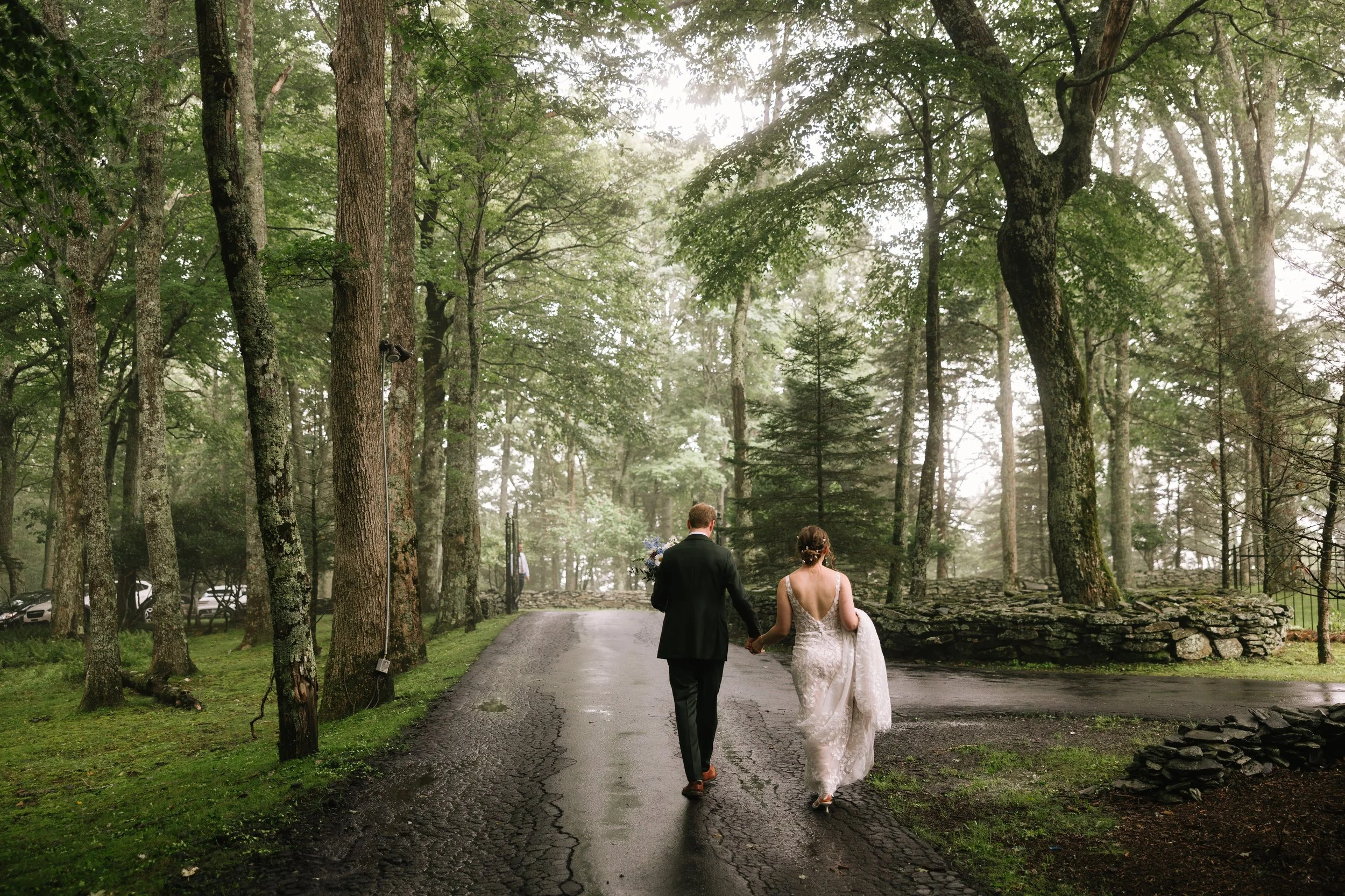 Bride and groom walking together on a quiet forest road after their mountain wedding ceremony.