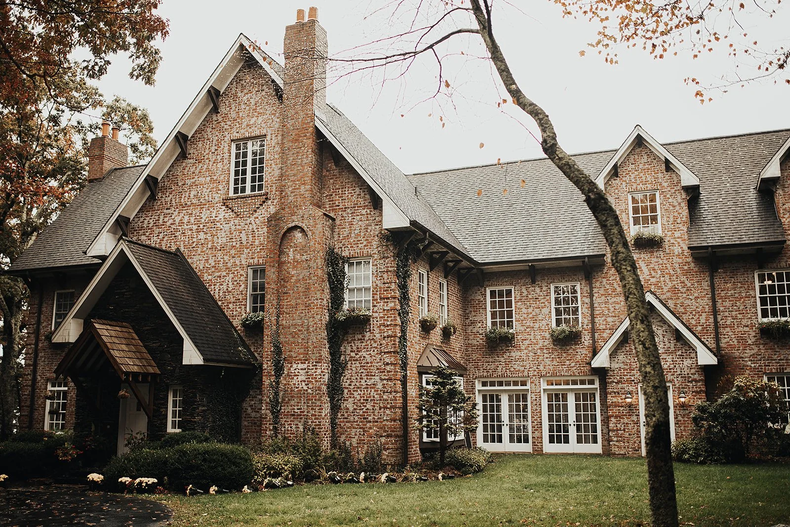 Guests seated at a mountaintop wedding ceremony facing a floral wooden cross with mountain views beyond