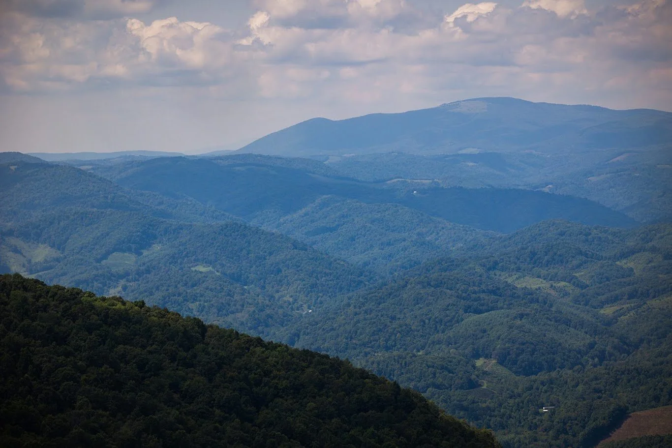 Wide scenic view of layered Blue Ridge Mountains under a partly cloudy sky