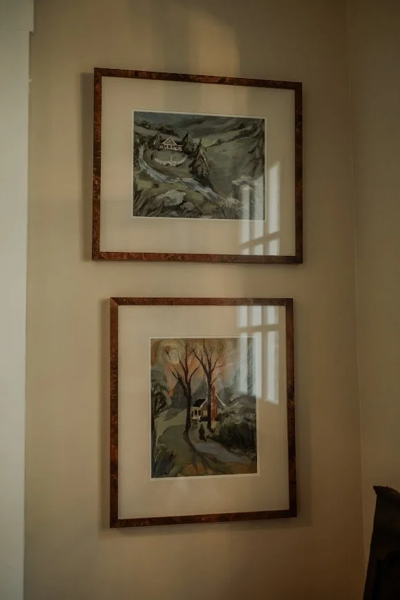 Framed artwork on an interior wall with warm light and shadows